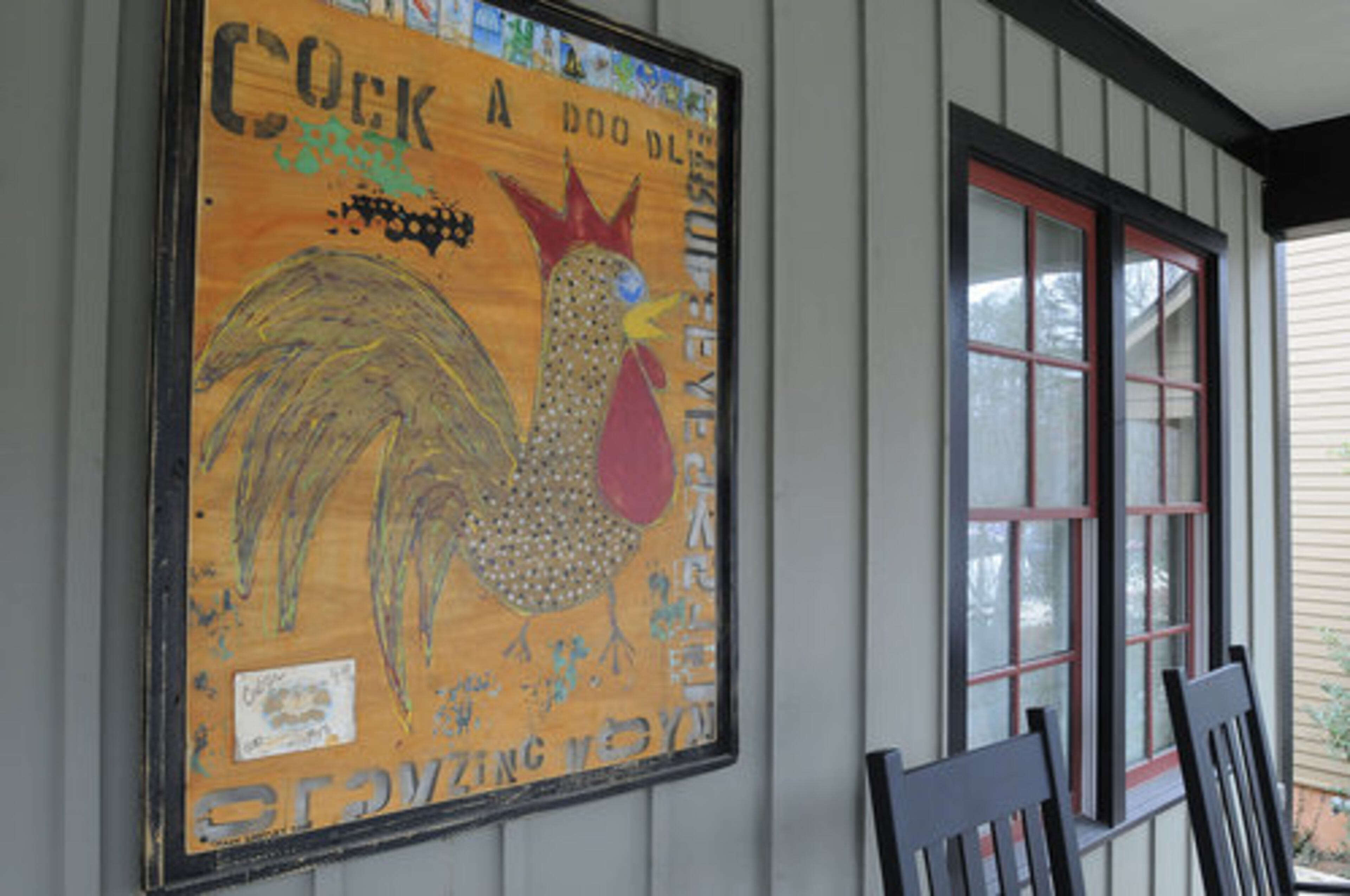 Susan Isakson shows off some folk art that adorns the walls of the deck area of her Serenbe home. Appreciation of art and nature is important to the Serenbe community, located in Palmetto, which is only about 30 minutes from Atlanta.