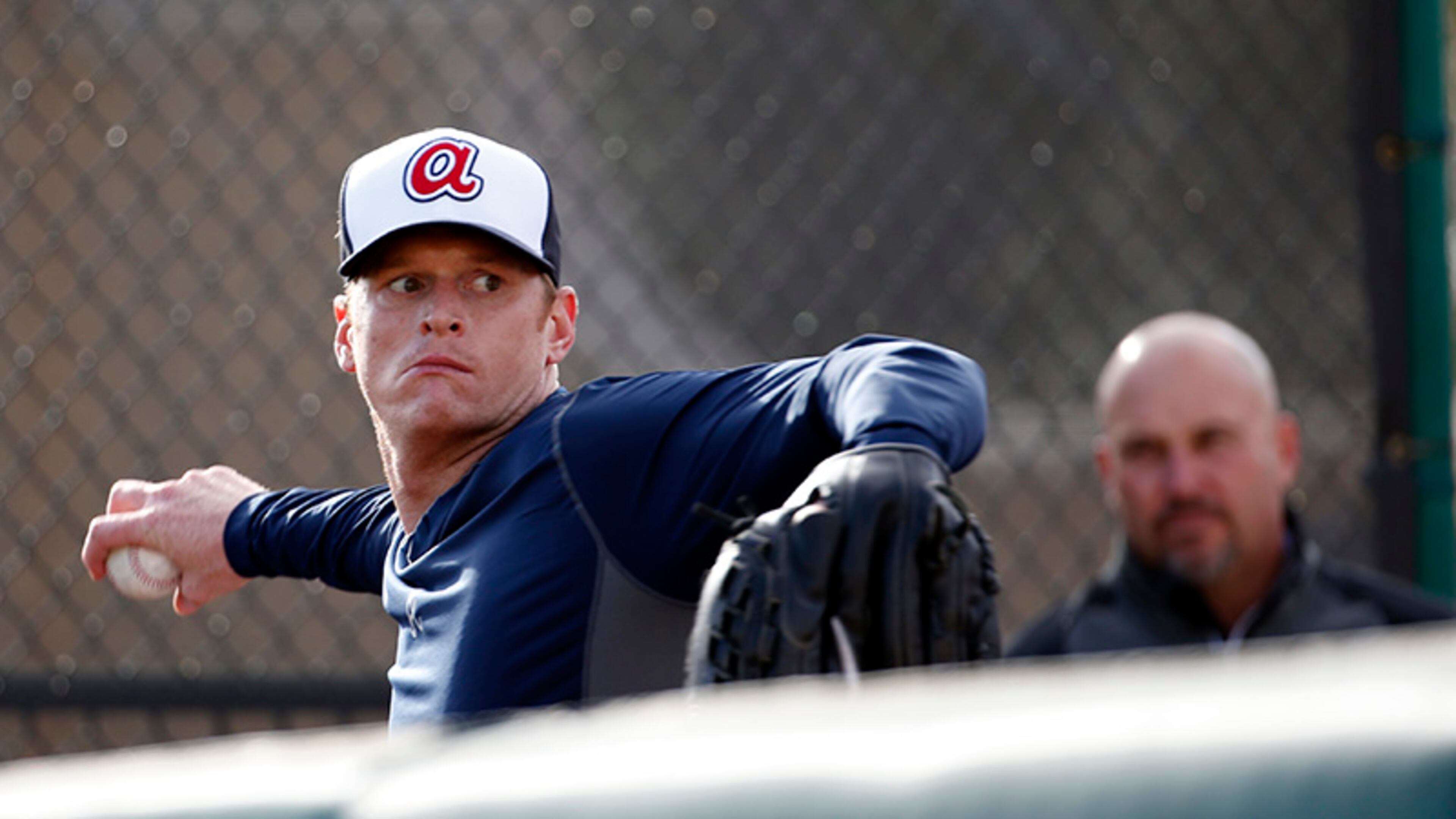 Braves manager Fredi Gonzalez (background) watches as pitcher Gavin Floyd takes part in throwing exercises during a spring training baseball workout Thursday in Lake Buena Vista, Fla.