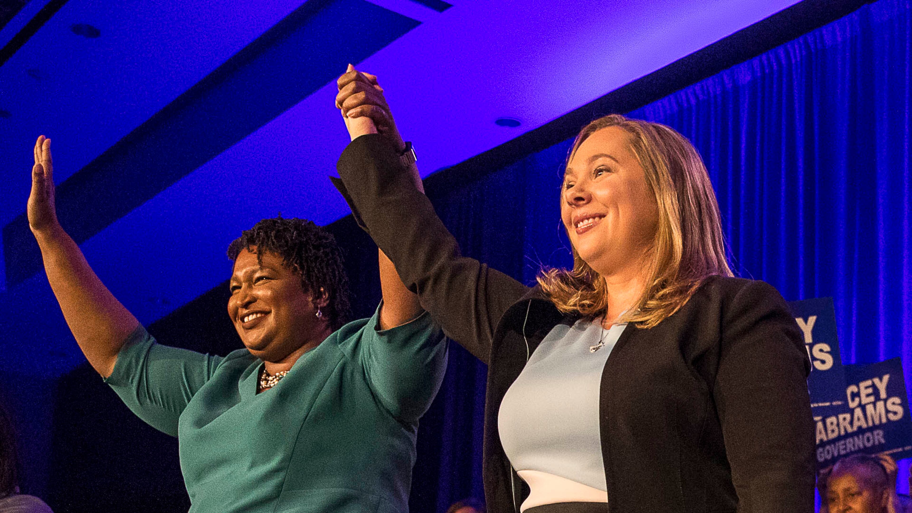 Gubernatorial nominee Stacey Abrams links hands with Sarah Riggs Amico, the nominee for lieutenant during the Georgia Democrat convention in 2018. AJC file