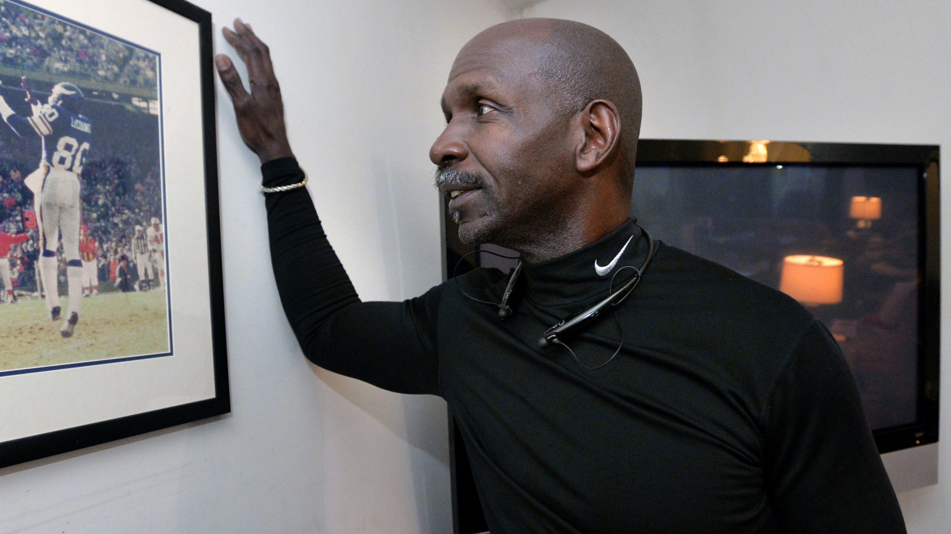 Terry LeCount looks at a photo from his years as an NFL player with the Minnesota Vikings. LeCount struggled with addiction but went on to spend a decade as a paraprofessional at Oakhurst Elementary School in Decatur and now works at the College Football Hall of Fame Museum. HYOSUB SHIN / HSHIN@AJC.COM