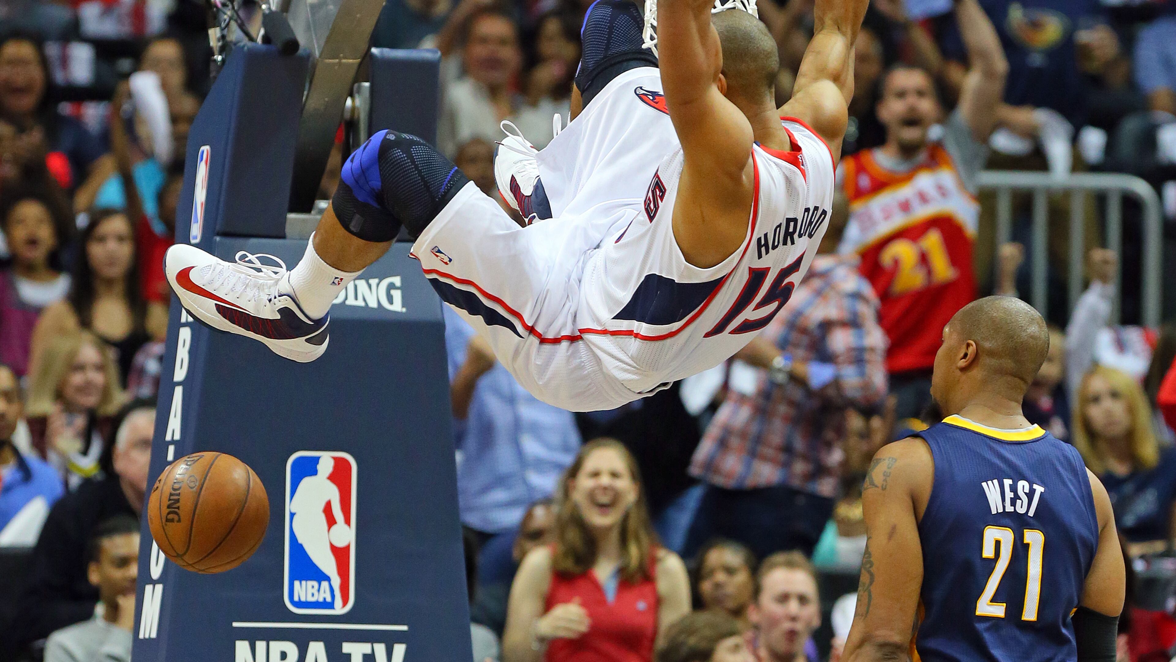 Hawks forward Al Horford hangs on the basket slamming over Indiana forward David West on April 27, 2013. CURTIS COMPTON/ CCOMPTON@AJC.COM