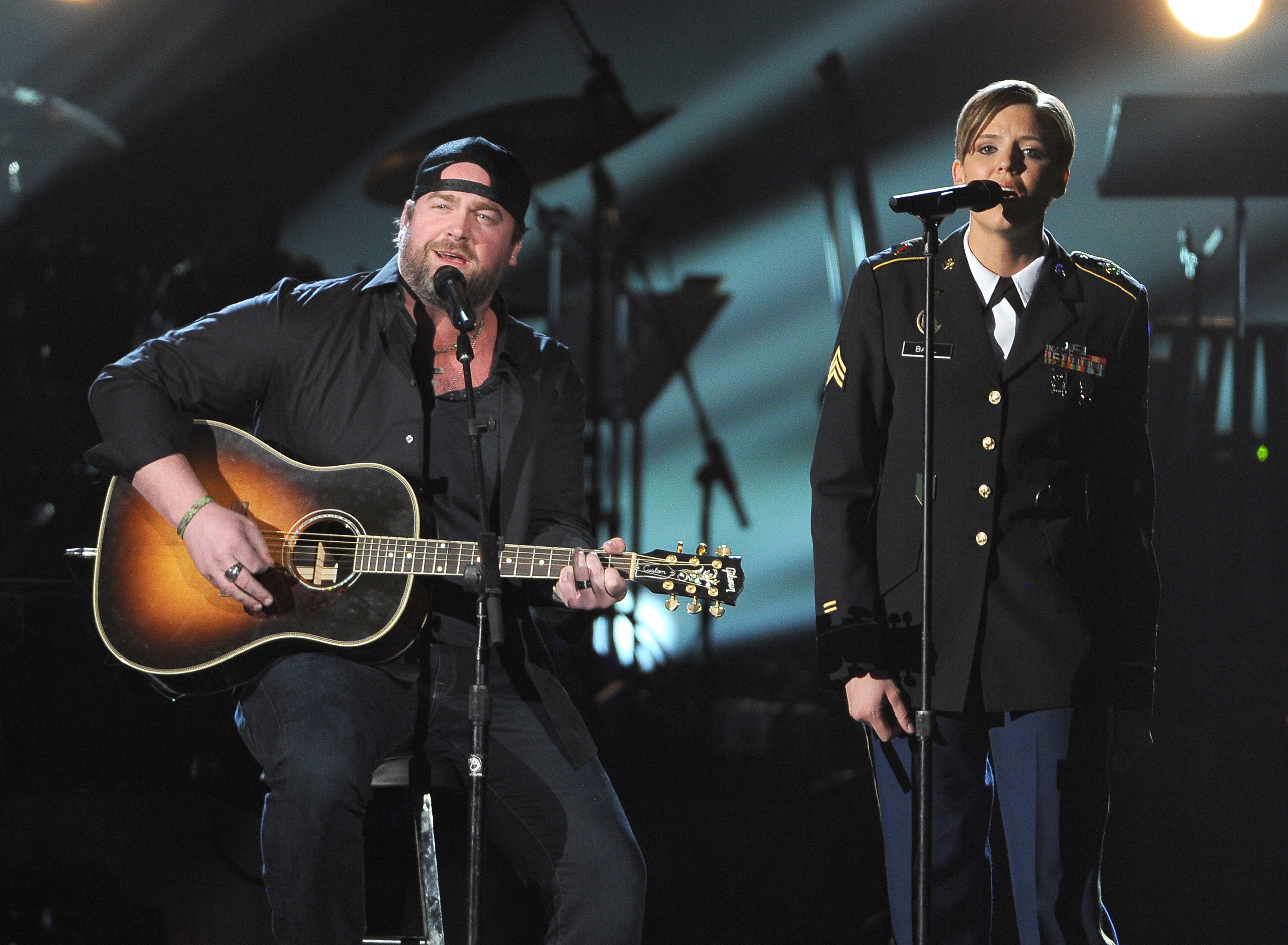 Lee Brice, left, and Christiana Ball, of the U.S. Army, perform at ACM Presents an All-Star Salute to the Troops on Monday, April 7, 2014, in Las Vegas. (Photo by Chris Pizzello/Invision/AP)