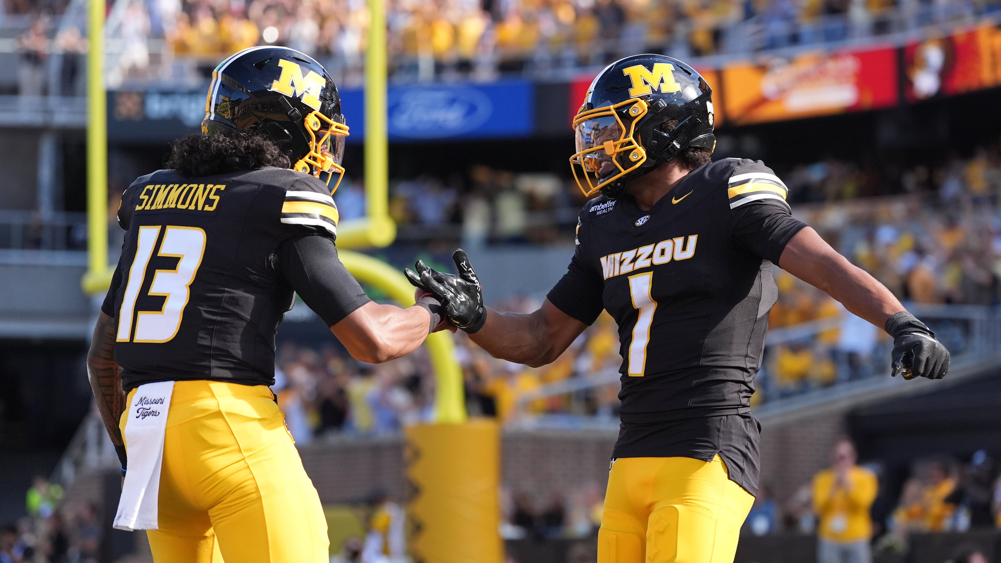 Missouri wide receiver Donovan Olugbode (1) is congratulated by quarterback Austin Simmons (13) after scoring during the first half of an NCAA college football game against Florida Saturday, Oct. 3, 2026, in Columbia, Mo. (AP Photo/Jeff Roberson)
