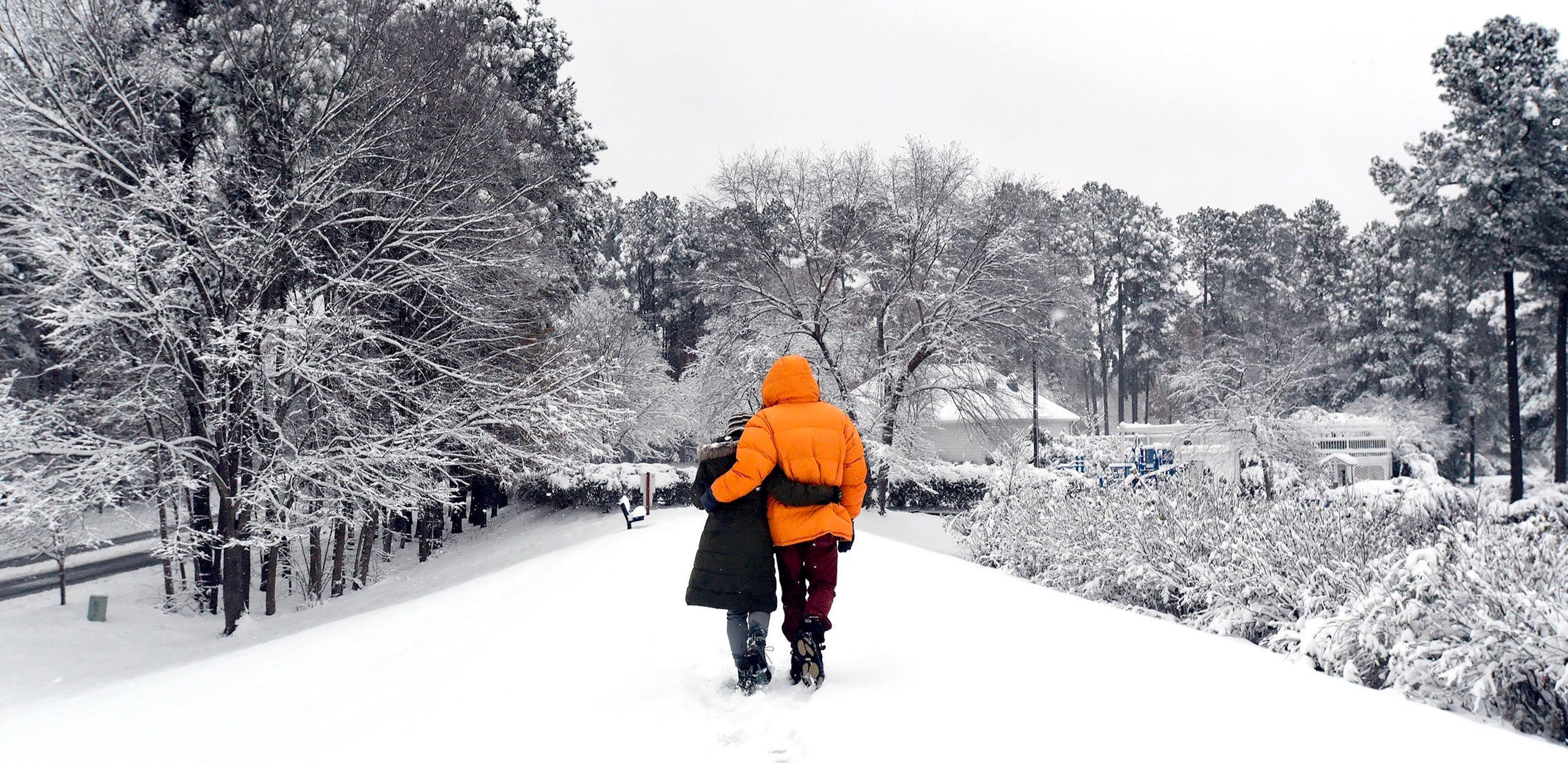 Shawn Hart and Greg Fontain take in the beauty of the first snowfall of the season in Durham, N.C. Sunday, Dec. 9, 2018 as heavy snow blankets the area. (Chuck Liddy/The News & Observer via AP)