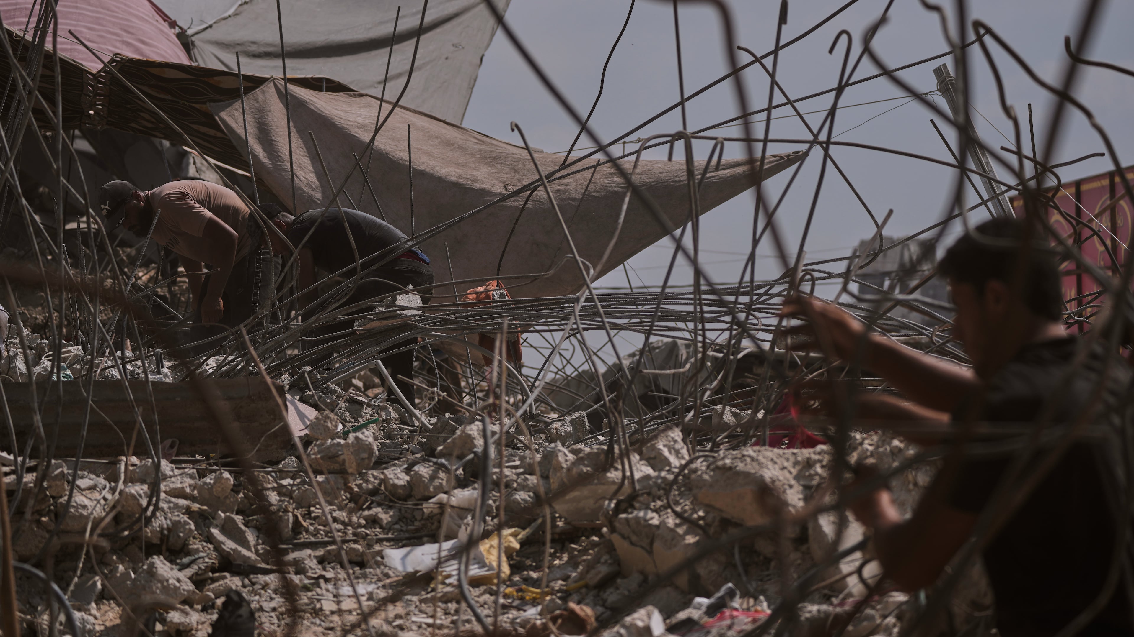 Palestinians remove iron from the rubble of buildings destroyed by Israeli airstrikes during the war with Hamas, repair and recycle it for construction, building tents or selling it, in Gaza City, Sunday, Aug. 16, 2026. (AP Photo/Jehad Alshrafi)