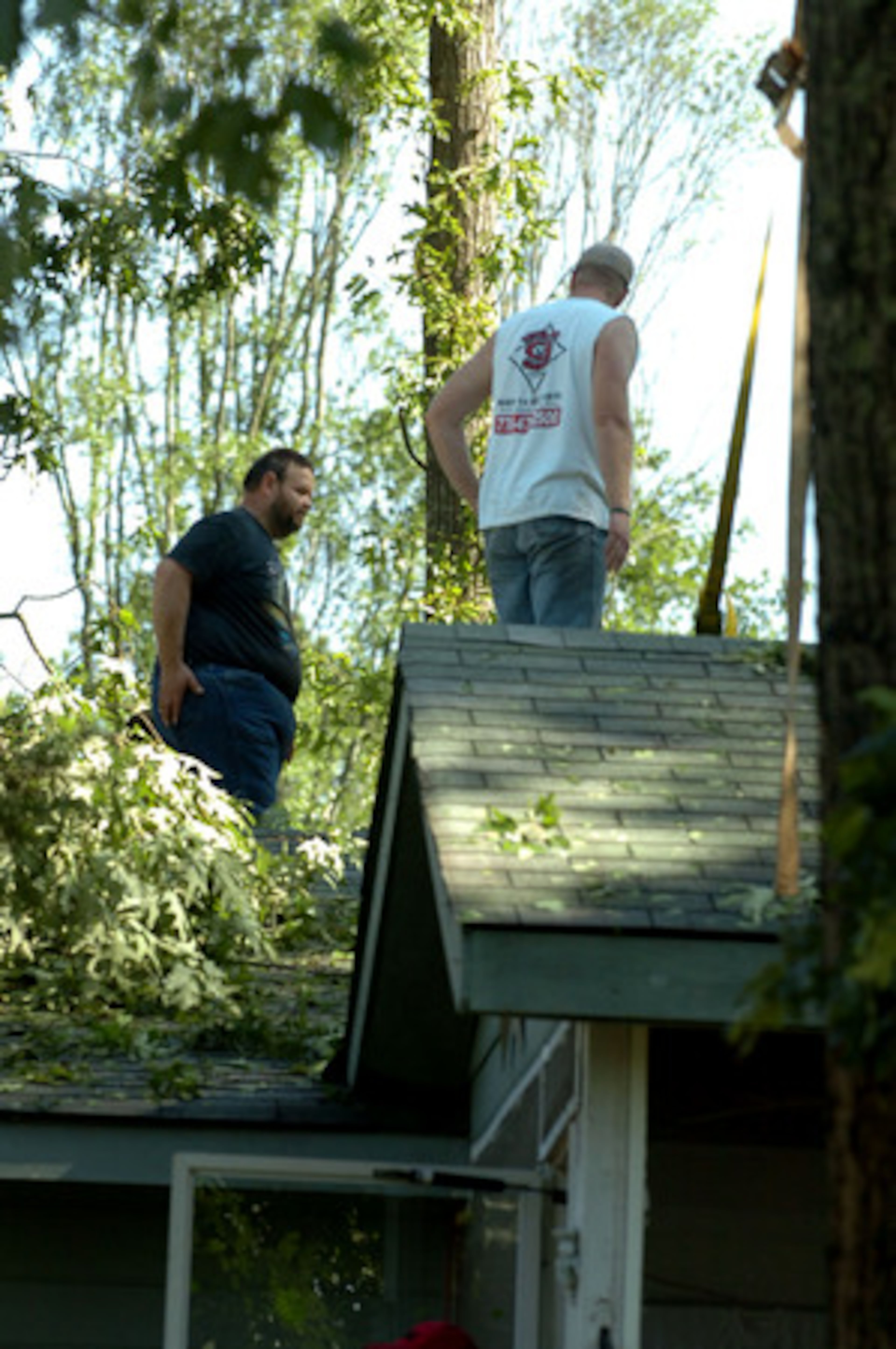 Residents clean off rooftops in Woodstock. Many trees were knocked down in the Woodstock and Holly Springs area, leaving people without electricity.