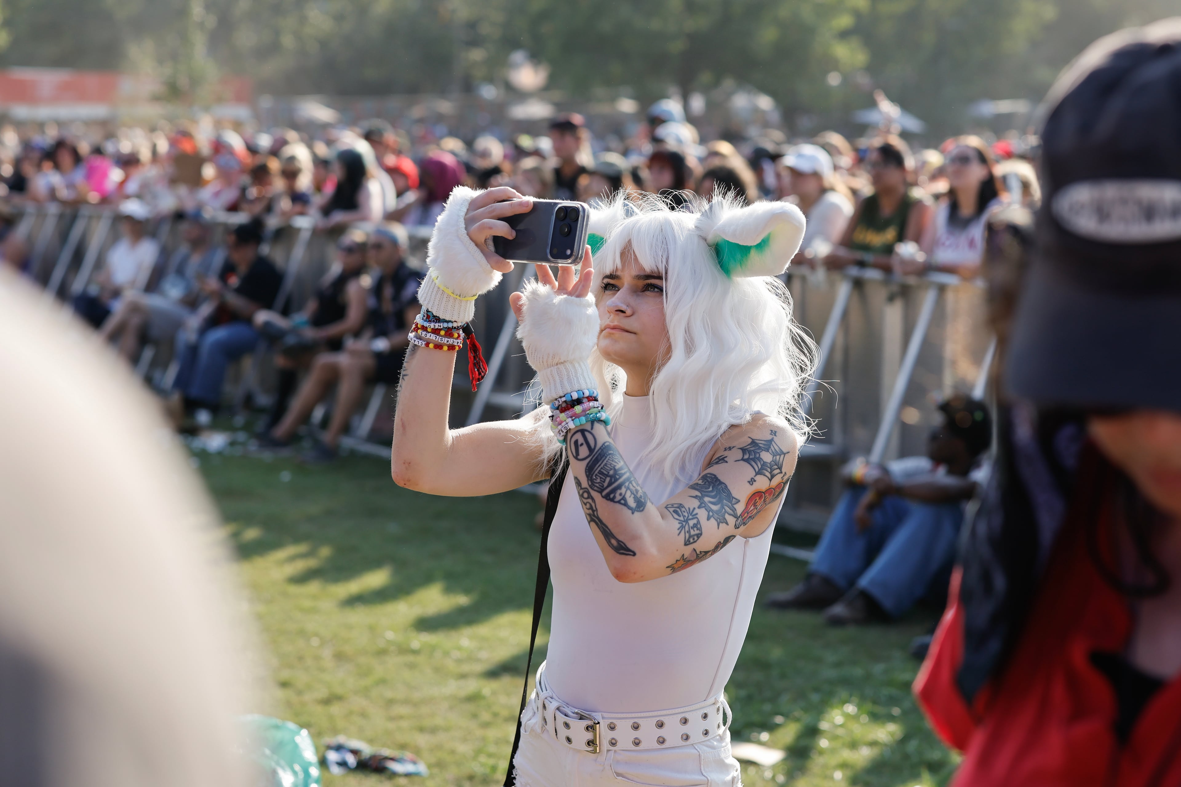 A fan listens to Peach Pit perform during the Shaky Knees music festival at Piedmont Park, Saturday, Sept. 19, 2026, in Atlanta. (Erik S. Lesser for the AJC)