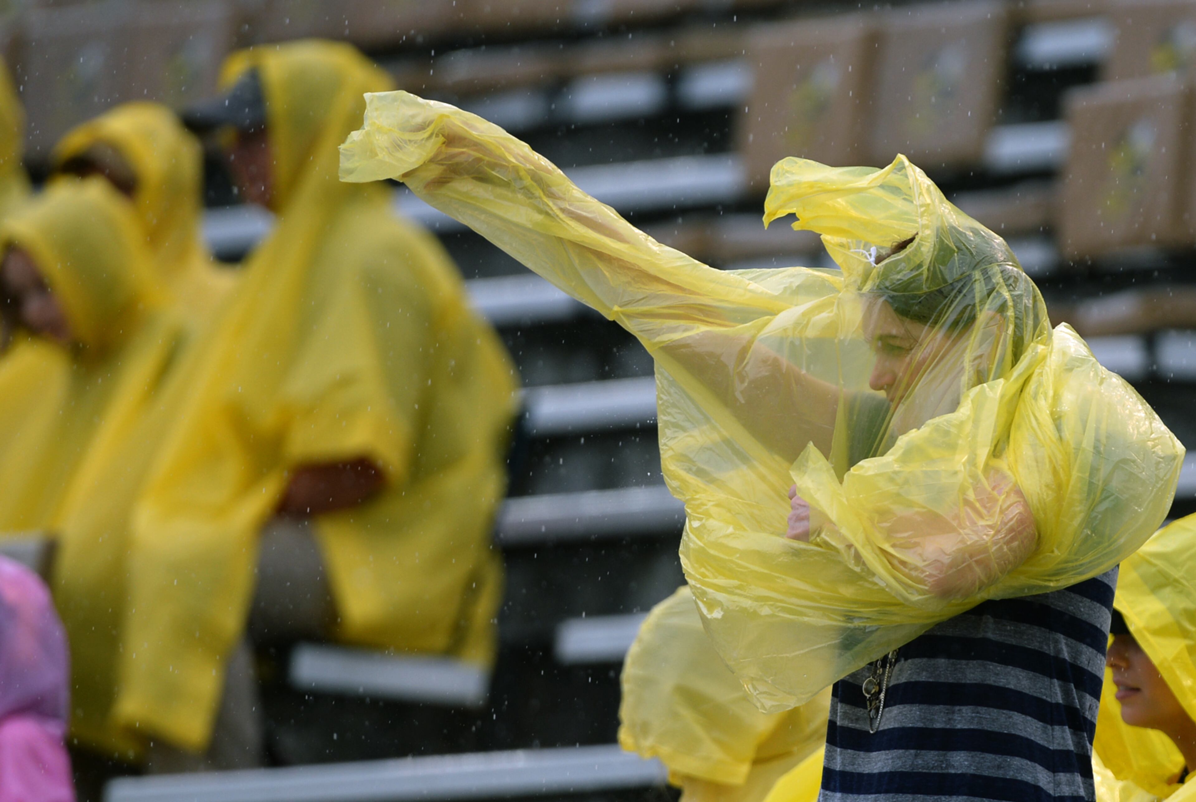 A Georgia Tech fan puts on her poncho in the rain in Bobby Dodd Stadium before the start of the Georgia Tech vs North Carolina game.