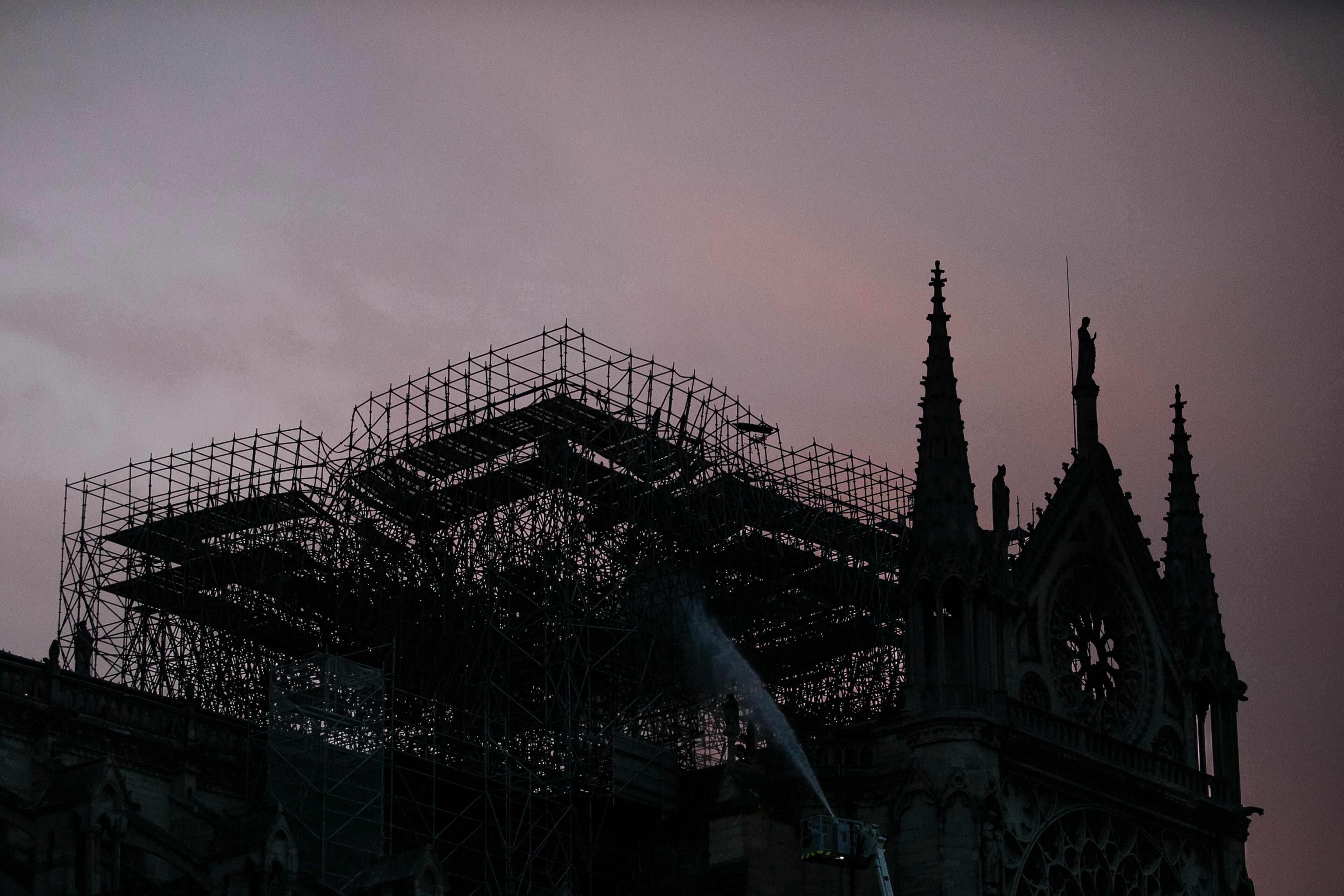 The Notre Dame cathedral is seen on sunrise as firefighters operate after the fire in Paris, Tuesday, April 16, 2019. A catastrophic fire engulfed the upper reaches of Paris' soaring Notre Dame Cathedral as it was undergoing renovations Monday, threatening one of the greatest architectural treasures of the Western world as tourists and Parisians looked on aghast from the streets below. (AP Photo/Kamil Zihnioglu)