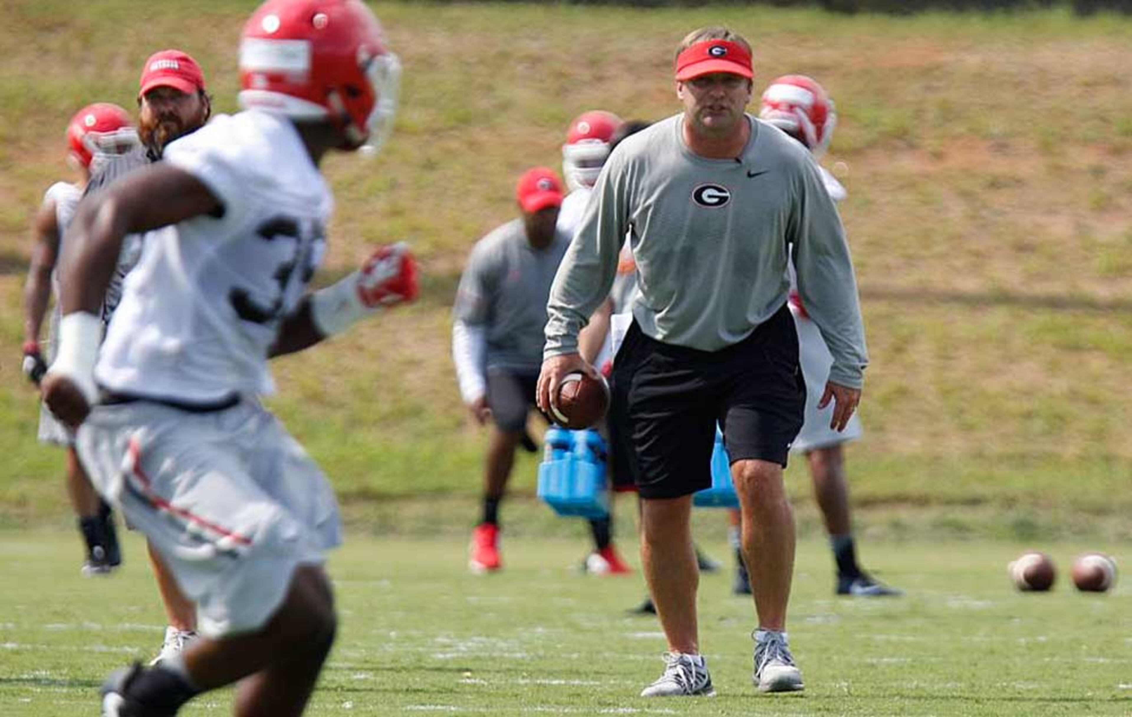 UGA coach Kirby Smart yells out commands while Aaron Davis (35) runs a drill at Monday's practice.