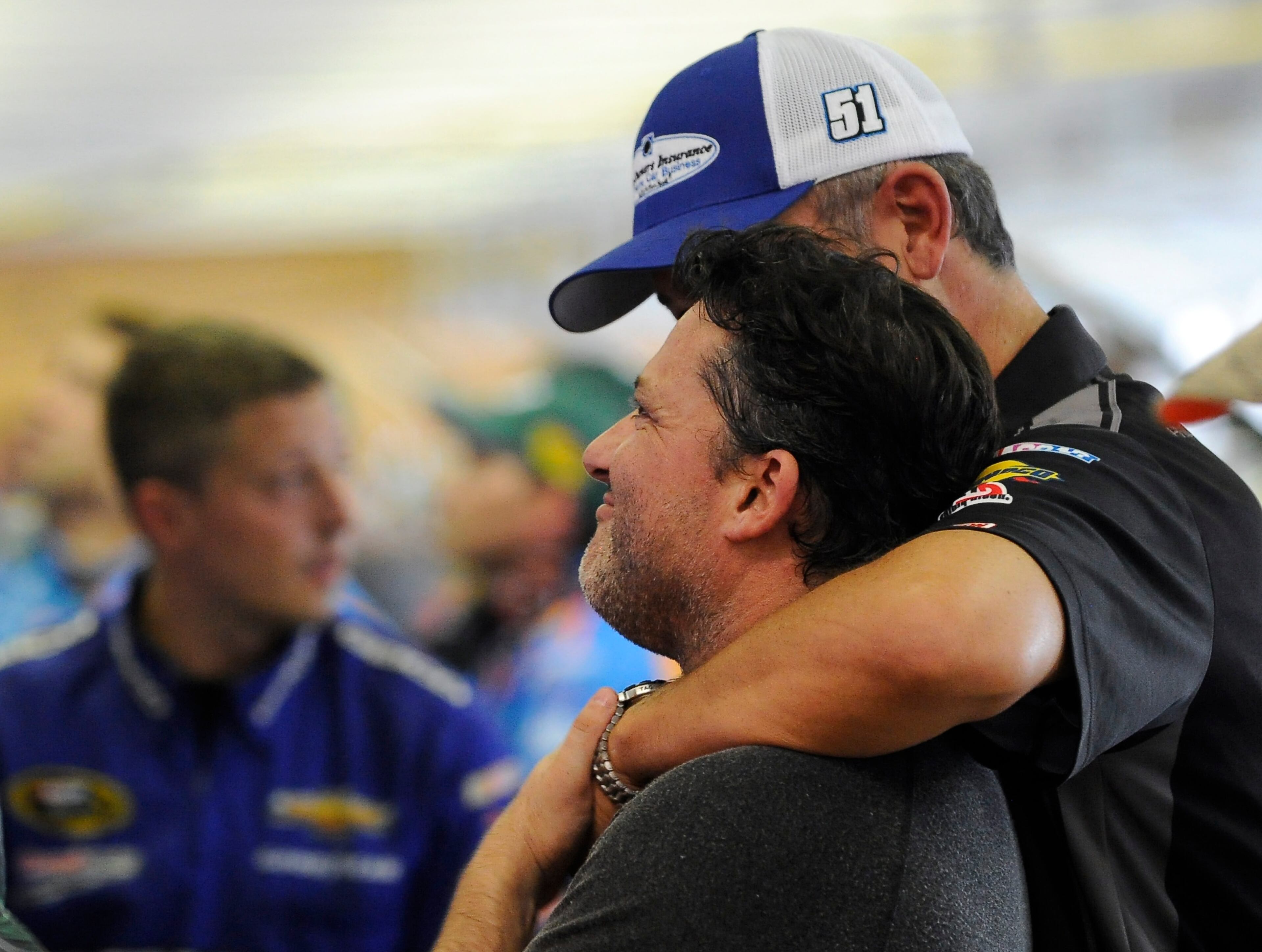 Sprint Cup Series driver Tony Stewart gets a hug from former crew chief Steve Addington in the garage during practice for Sunday's NASCAR Sprint Cup Series auto race at Atlanta Motor Speedway, Saturday, Aug. 30, 2014 in Hampton, Ga. (AP Photo/David Tulis)