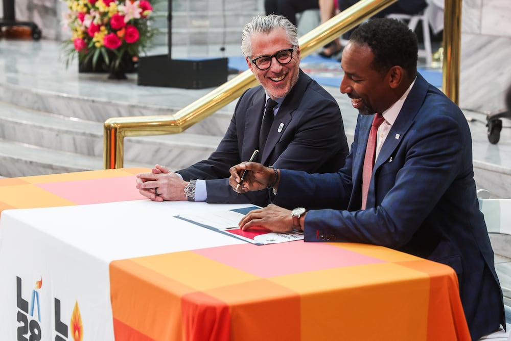 LA28 Chair and President Casey Wasserman (left) smiles with Atlanta Mayor Andre Dickens during the LA28 Olympic Torch Relay announcement at City Hall on Tuesday. (Abbey Cutrer for the AJC)