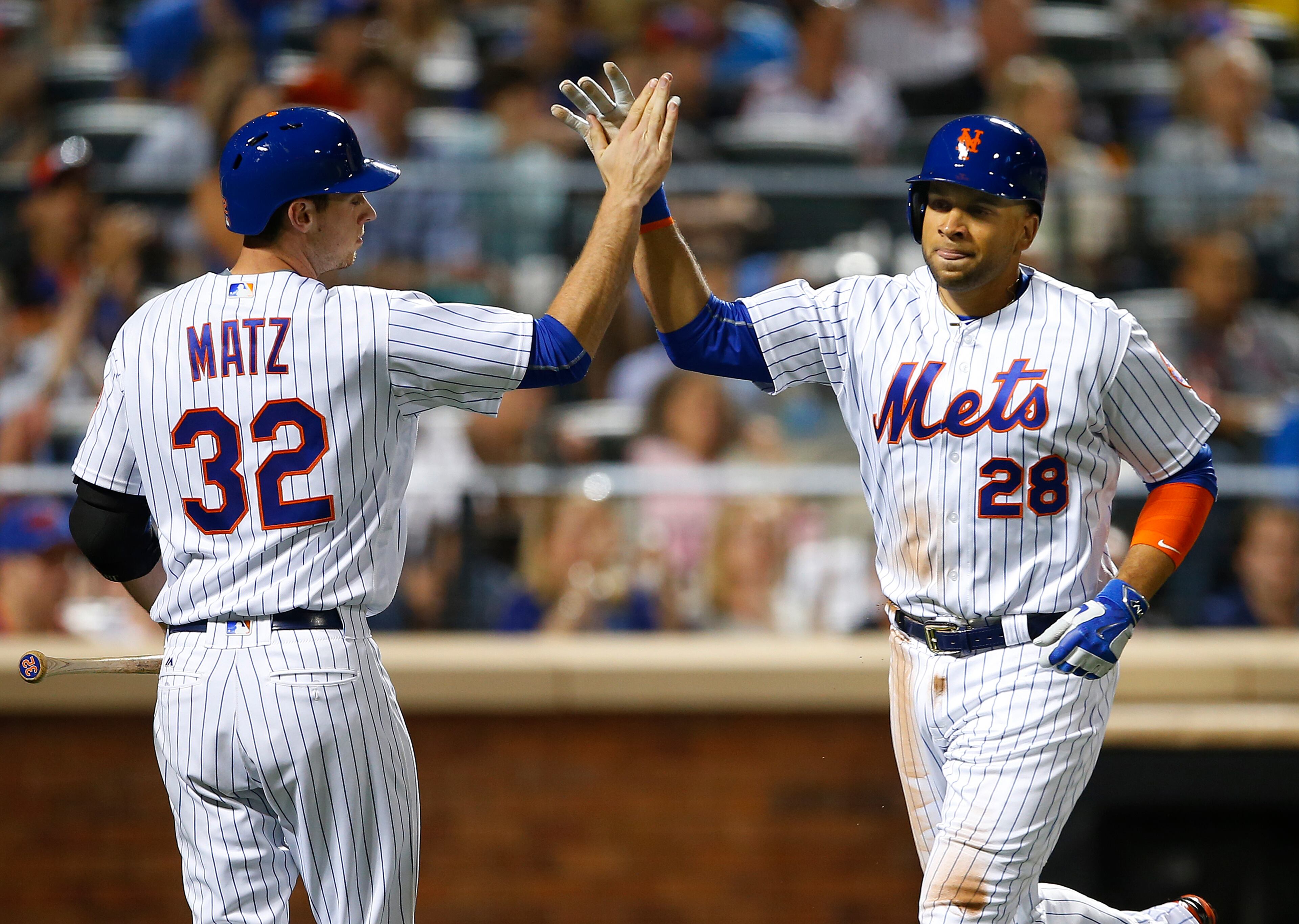 NEW YORK, NY - JUNE 18: James Loney #28 of the New York Mets is congratulated by Steven Matz #32 after scoring on a sacrifice fly by Rene Rivera #44 against the Atlanta Braves during the fourth inning of a game at Citi Field on June 18, 2016 in the Flushing neighborhood of the Queens borough of New York City. (Photo by Rich Schultz/Getty Images)