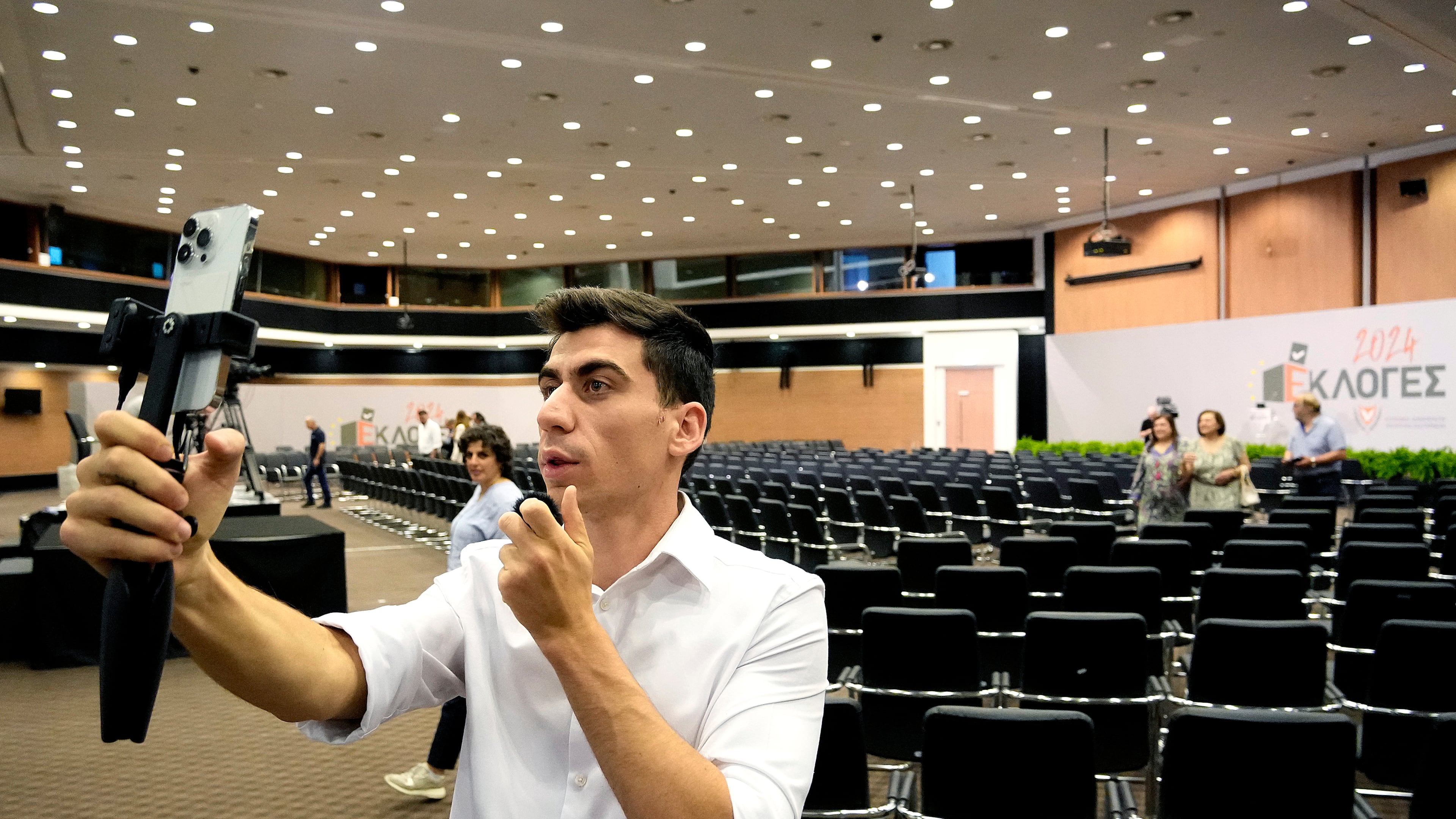 FILE - Popular YouTuber and TikToker with millions of online followers Fidias Panayiotou holds his cell phone after his proclamation as the winner of one of six seats allotted to Cyprus in the European Parliament in Nicosia, Cyprus, Tuesday, June 11, 2024. (AP Photo/Petros Karadjias, File)
