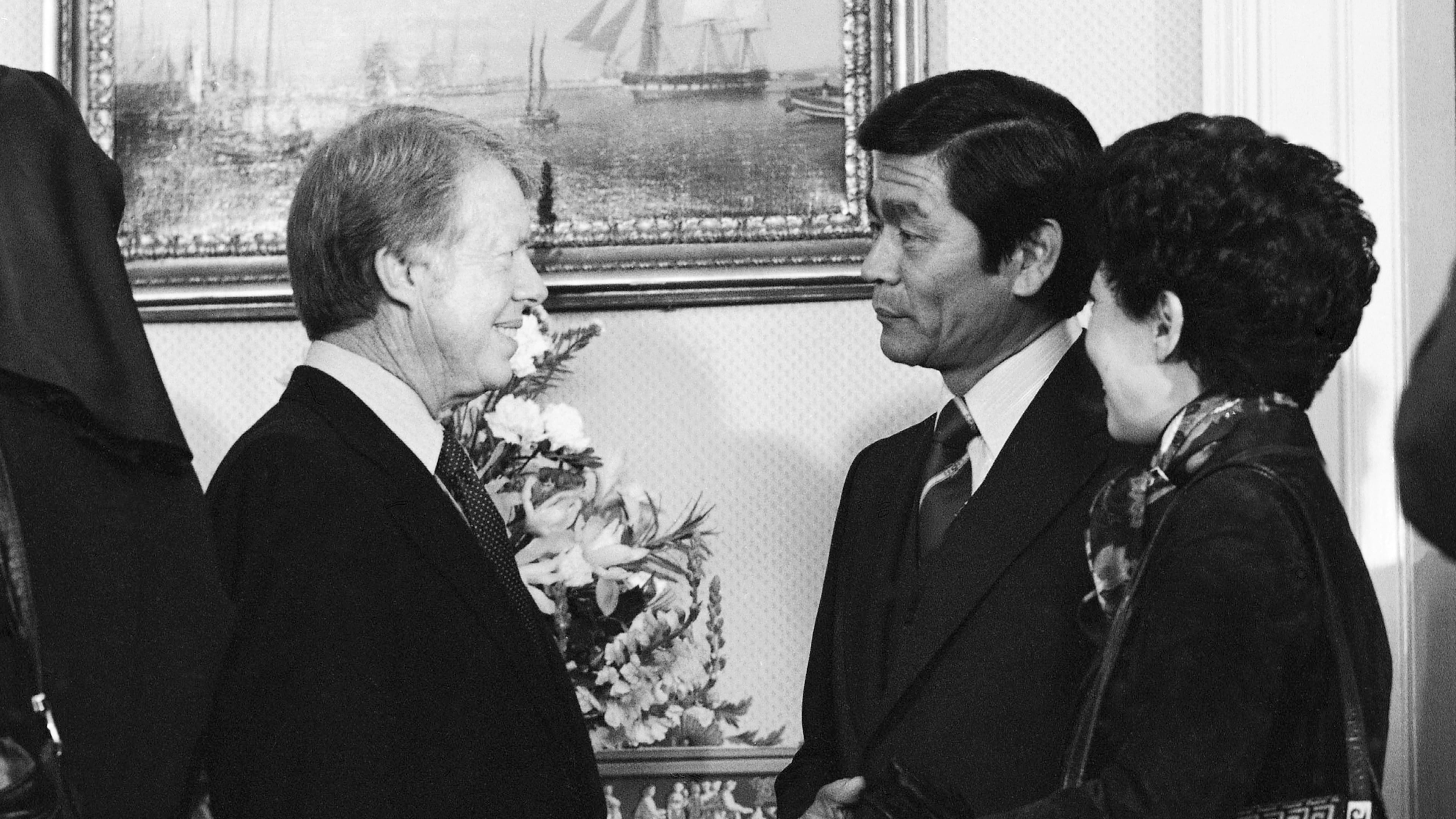 FILE - Hawaii Gov. George Ariyoshi, center, and his wife Jean chat with President Jimmy Carter during a White House reception for governors in Washington, Jan. 21, 1977. (AP Photo, File)
