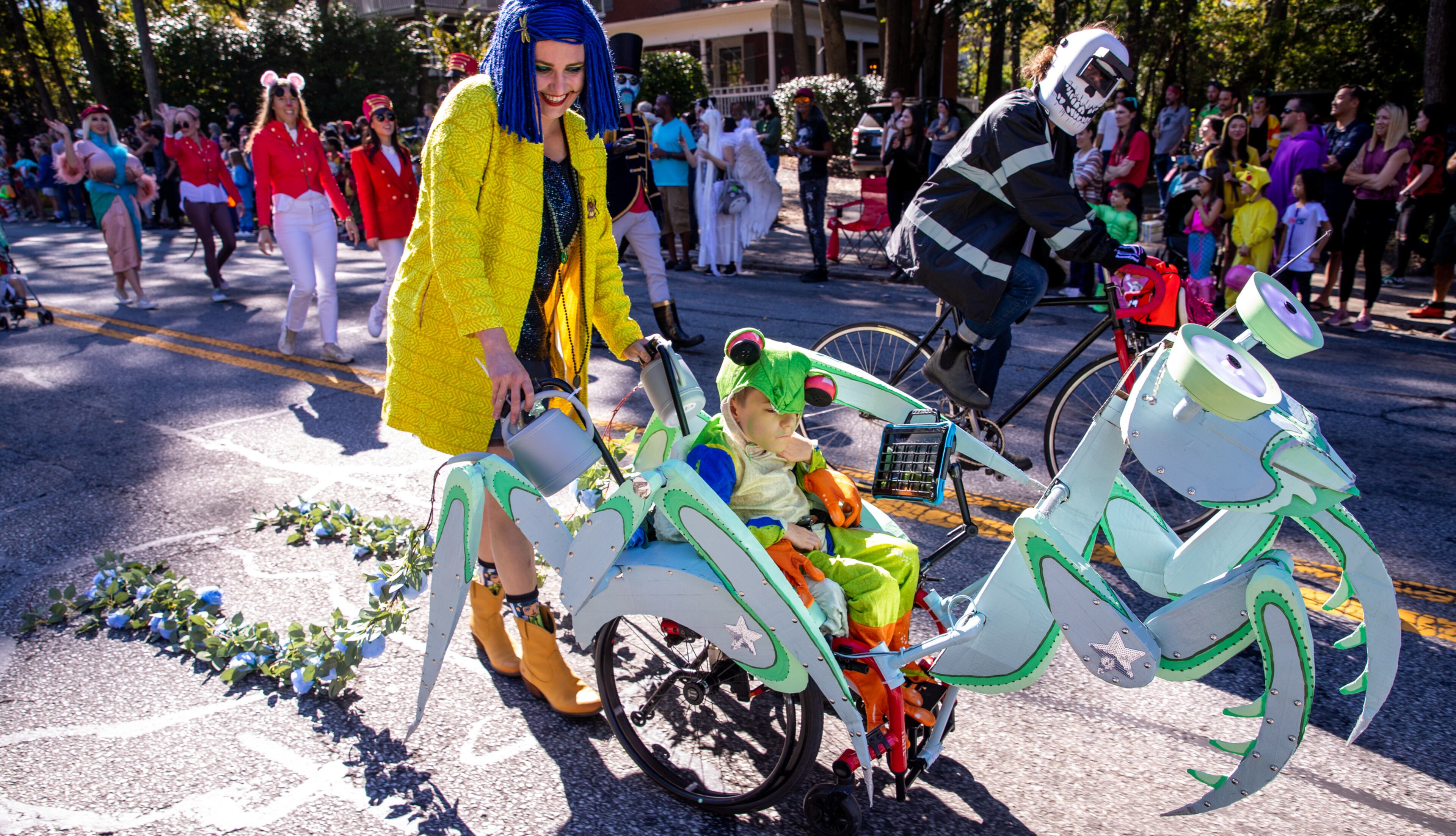 Lindsay Wilkinson operates the praying mantis carrying her son Miles Wilkinson, 8, in the annual Little Five Points Halloween Parade on Sunday, Oct 23, 2022. (Jenni Girtman for The Atlanta Journal-Constitution)