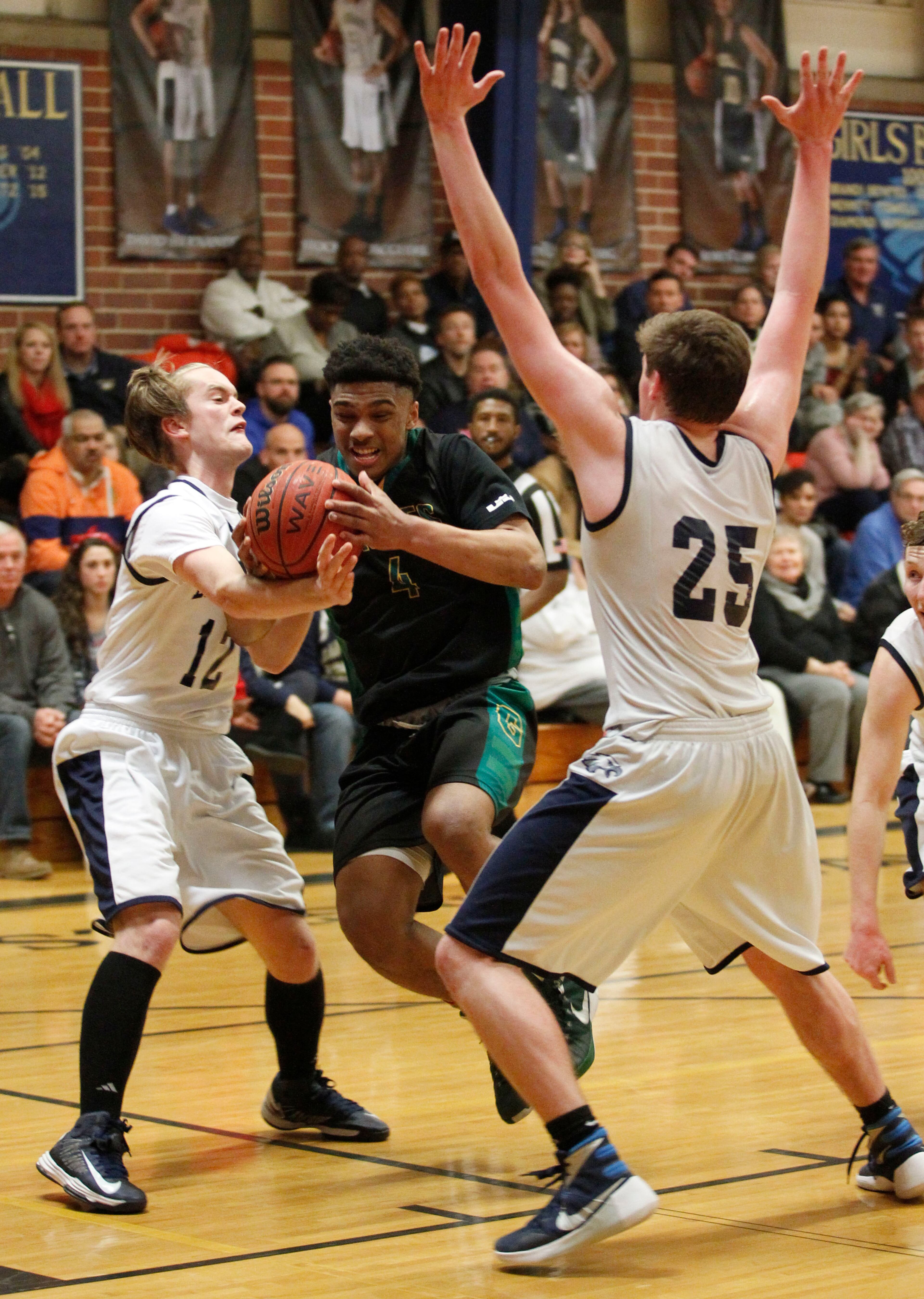 Greenforest Christian Justin Forrest (4) drives betweenLandmark Christian Luke Vineyard (12) and Zack Allen (25) at a high school basketball game at Landmark Christian school Friday, February 5, 2016. TAMI CHAPPELL/SPECIAL TO THE AJC