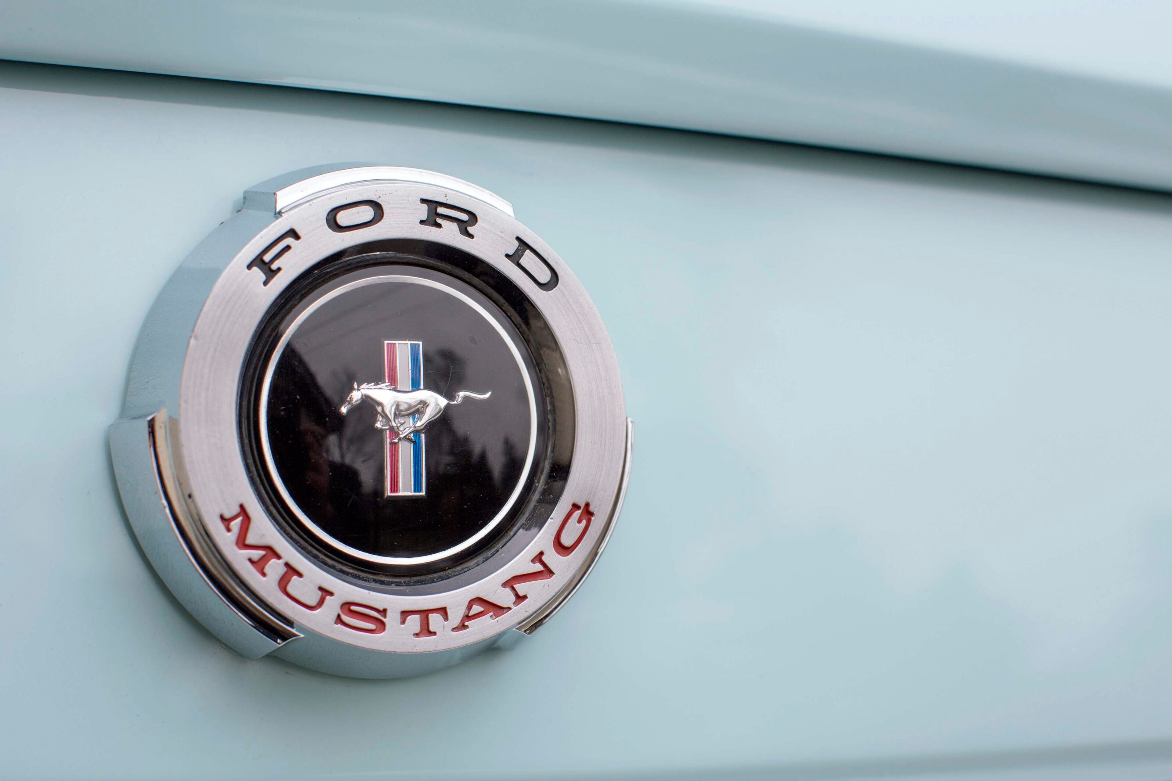 A Mustang badge is seen on Gail Wise's Skylight Blue 1964 1/2 Ford Mustang in Park Ridge, Illinois November 26, 2013. Gail Wise, then using her maiden name of Gail Brown, made the first known retail purchase of a Mustang on April 15, 1964, two days before the model went on sale. Ford will unveil its next-generation 2015 Mustang on December 5, 2013 for the model's 50th anniversary with simultaneous events in Michigan, Shanghai, Sydney, Barcelona, New York and Los Angeles. Picture taken November 26, 2013. REUTERS/John Gress