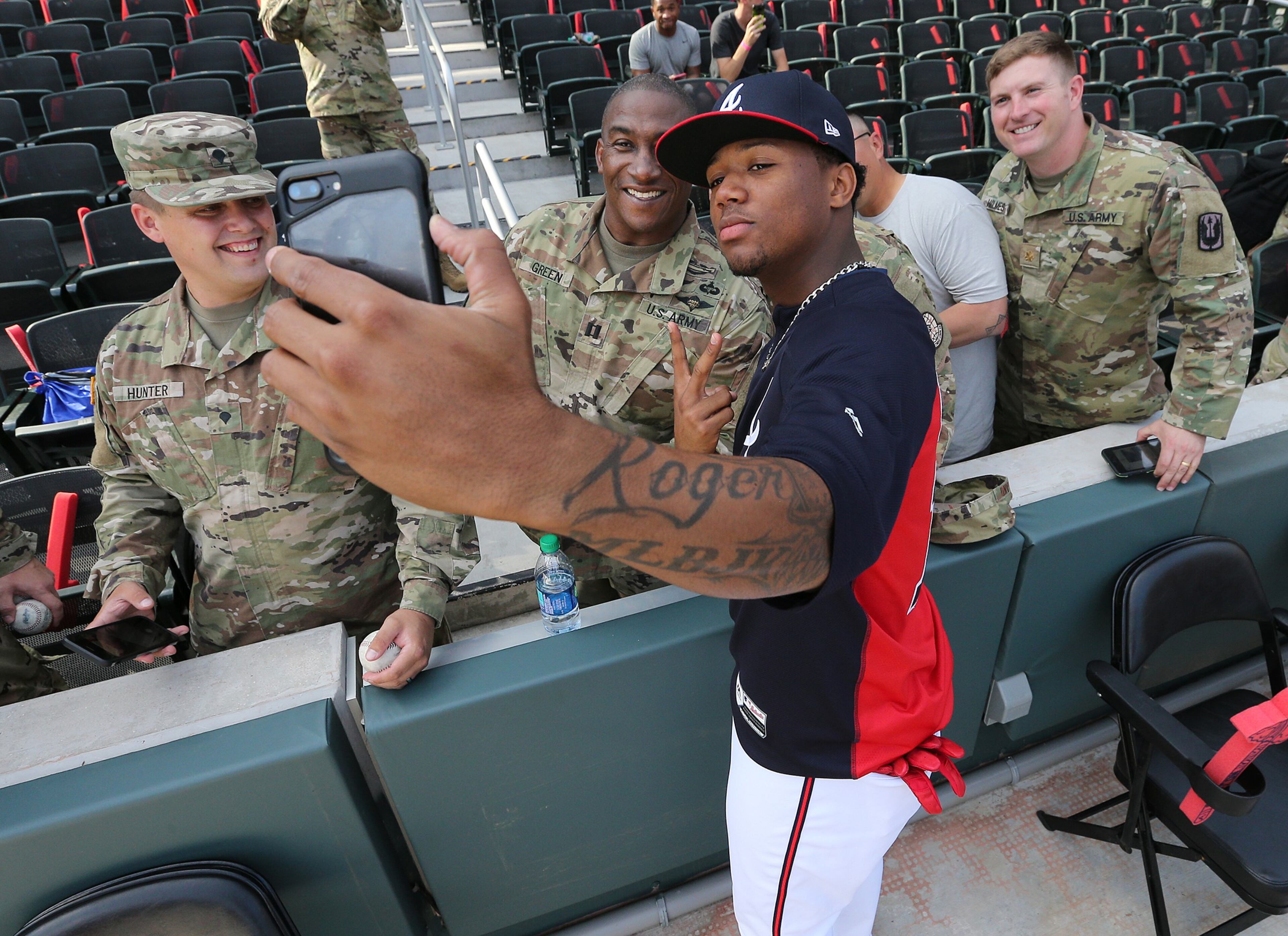 October 7, 2018 Atlanta: Atlanta Braves outfielder Ronald Acuna takes selfies with U.S. Army and Air Force members of the flag crew during batting practice before playing the Los Angeles Dodgers in Game 3 of a National League Division Series baseball game on Sunday, Oct 7, 2018, in Atlanta. Curtis Compton/ccompton@ajc.com