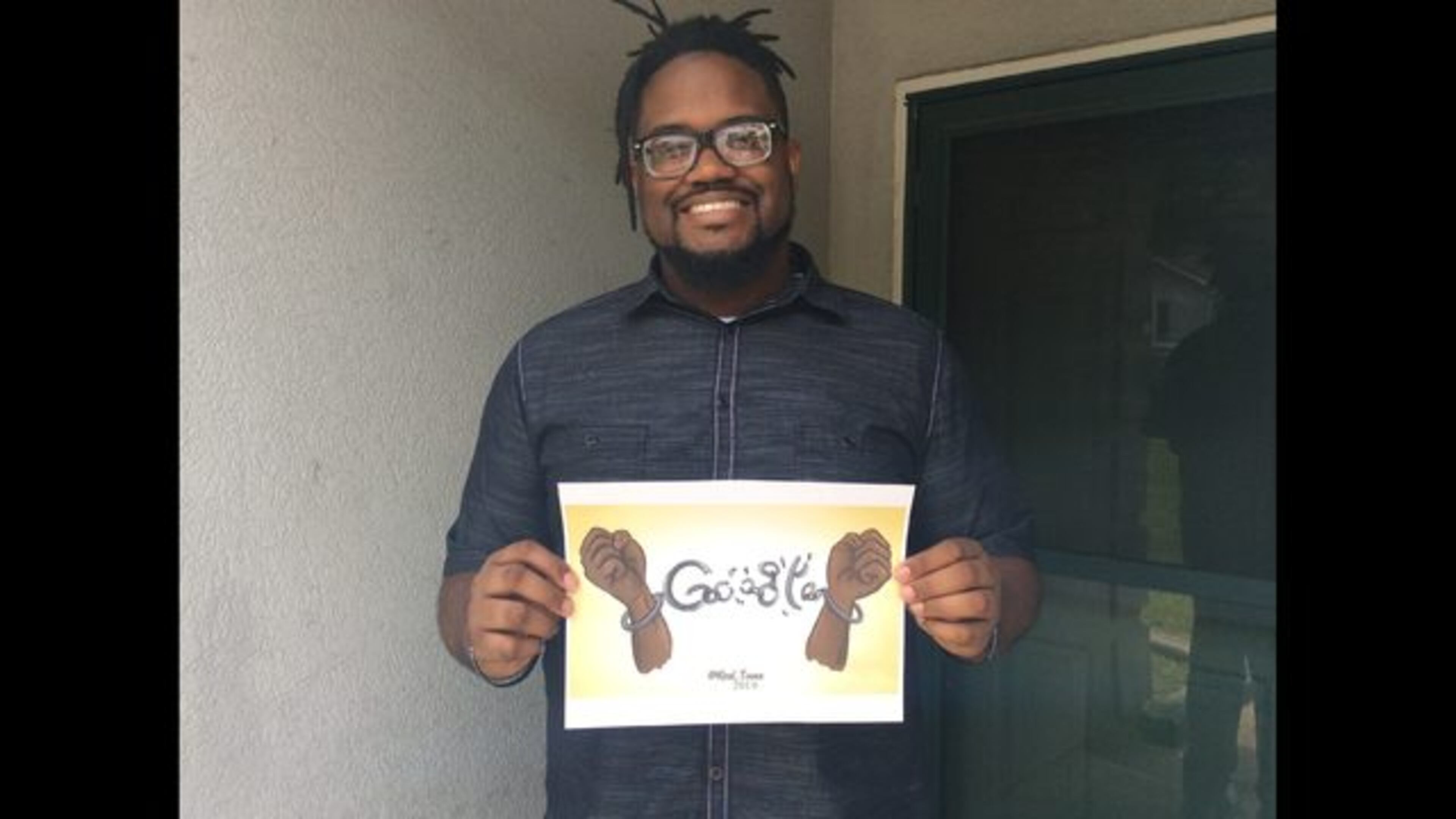 <p> Columbus digital artist Davian Chester poses for a portrait outside of his home in Columbus, Georgia on July 1, 2019, with a Google Doodle he made for Juneteenth. Now, he might have a job with the tech giant. (Nick Wooten/Ledger-Enquirer via AP) </p>