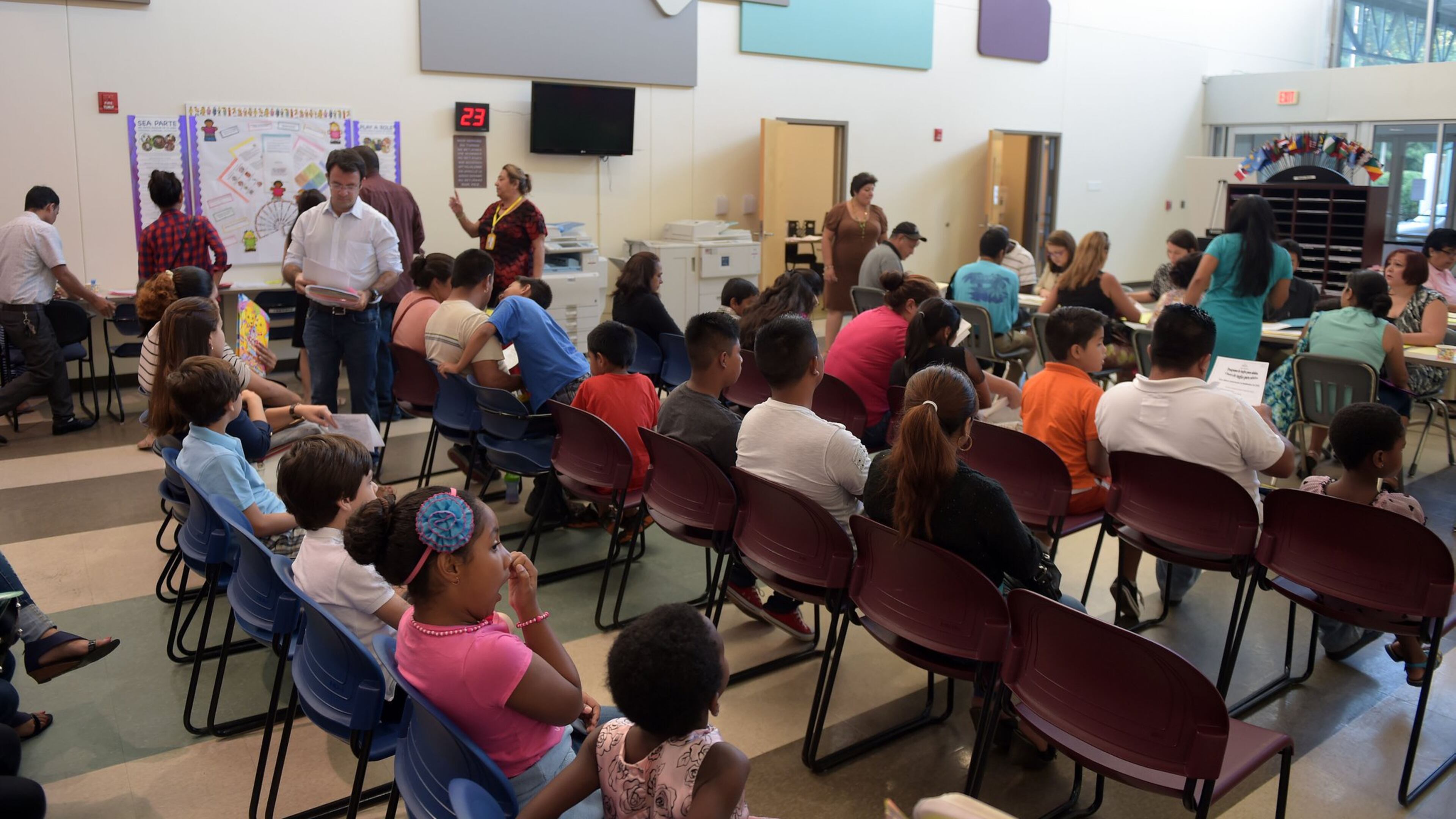 Parents wait to register their students at the DeKalb County International Welcome Center in Stone Mountain on Monday. DeKalb County officials hope a new appointment system will fix years of trying to register international students and getting bogged down by language barriers, missing documentation and long lines reminiscent of Black Friday sales shopping. The district boasts some 22,000 international students, more than a fifth of its total 101,000. KENT D. JOHNSON /KDJOHNSON@AJC.COM