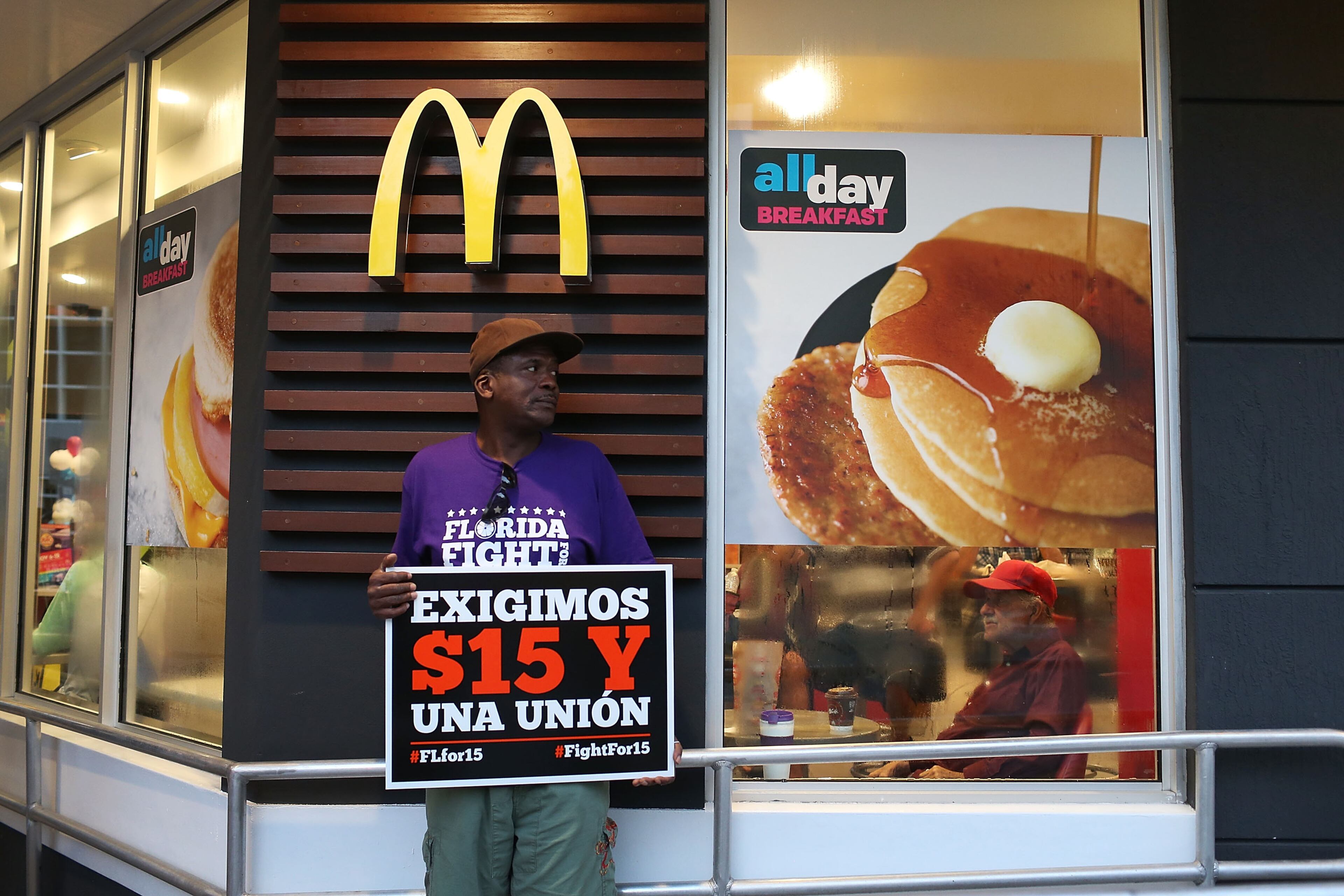 MIAMI, FL - NOVEMBER 10: Ben Lane joins other workers to protest outside a McDonald's restaurant on November 10, 2015 in Miami, Florida. The protesters are demanding action from state legislators and presidential candidates to raise the minimum wage to $15 an hour. (Photo by Joe Raedle/Getty Images)