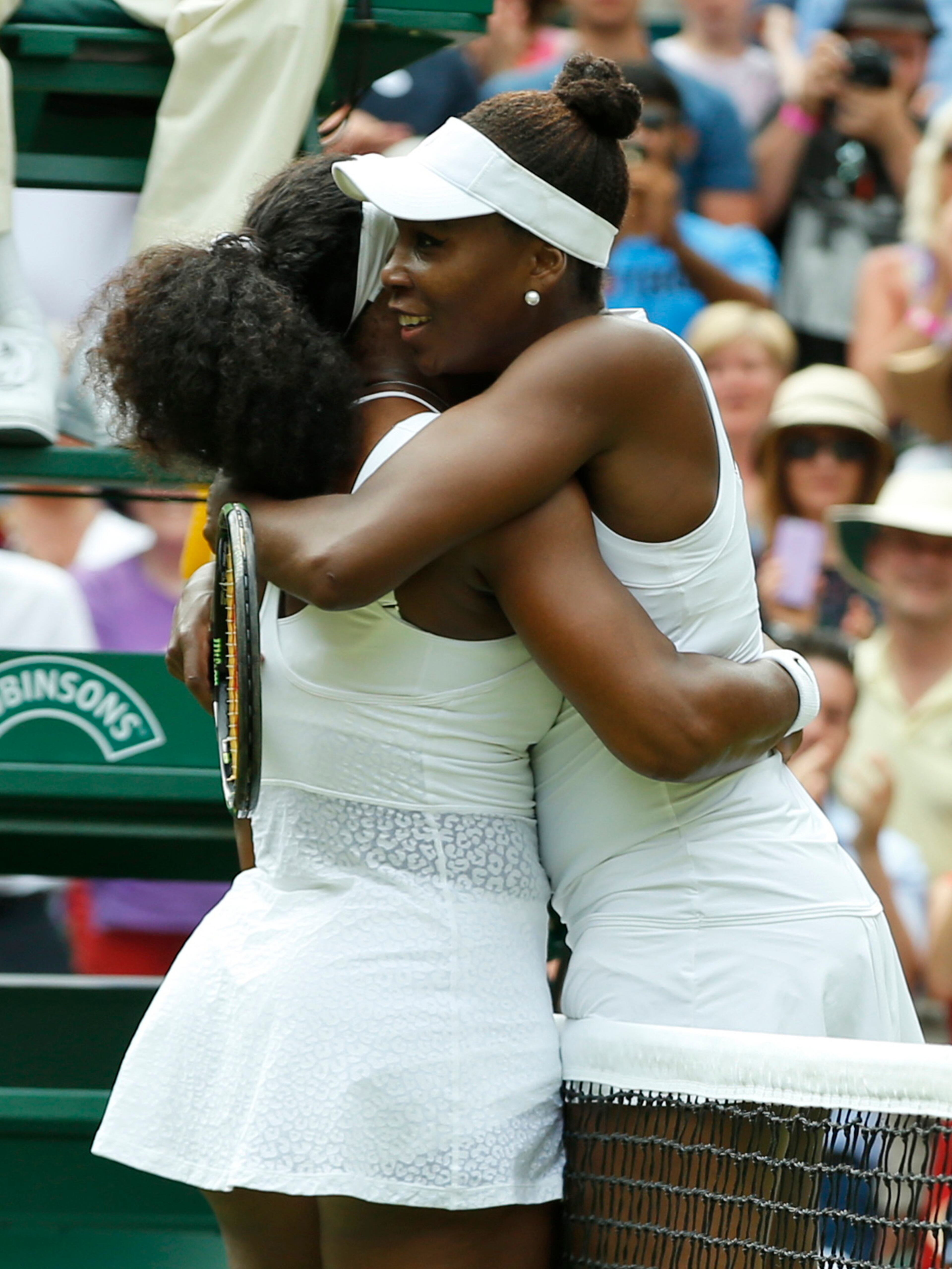 Serena Williams of the United States, left, hugs her sister Venus Williams of the United States after winning their singles match, at the All England Lawn Tennis Championships in Wimbledon, London, Monday July 6, 2015. Serena Williams won 6-4, 6-3. (AP Photo/Alastair Grant)