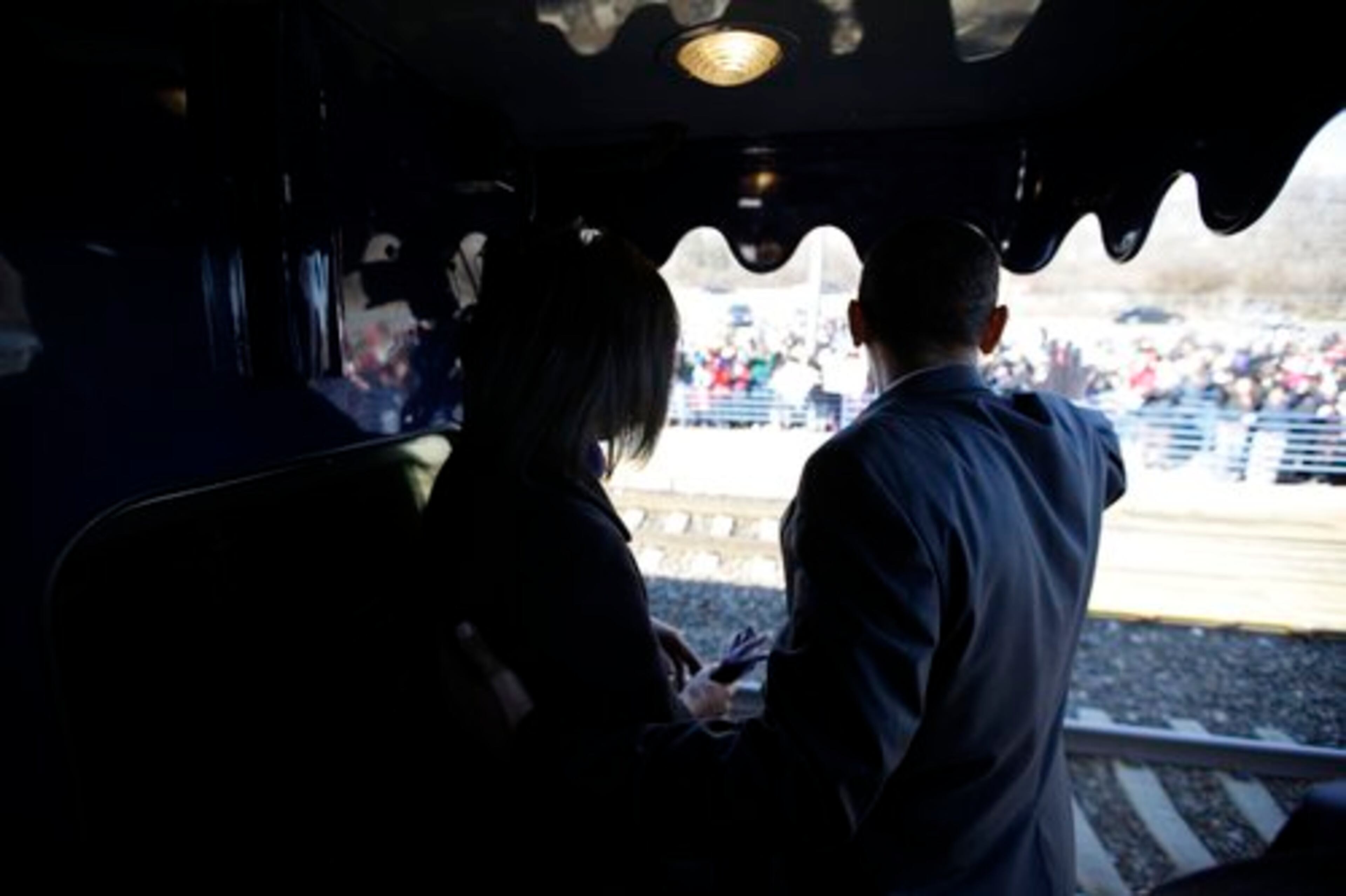 President-elect Barack Obama, accompanied by his wife Michelle Obama, waves during his inaugural whistle stop train trip in Wilmington , Del.