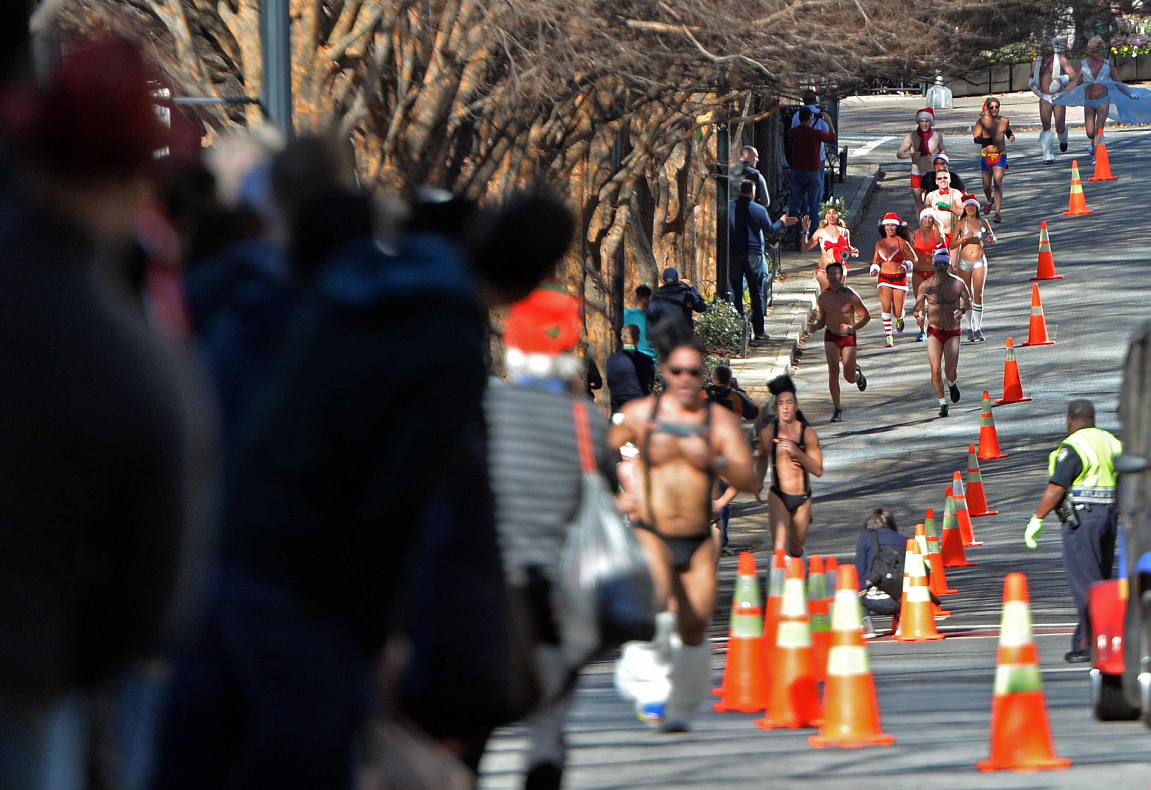 December 13, 2014 Atlanta - Runners approach the finish line near Hudson Grill Midtown on Peachtree Street during Atlanta Santa Speedo Run on Saturday, December 13, 2014. The race is run to raise money during the 2014 Santa Speedo Run. These 'lightly' dressed Santas are fundraising to support Everybody Wins! Atlanta, a nonprofit devoted to improving children's reading skills that below current grade level. HYOSUB SHIN / HSHIN@AJC.COM