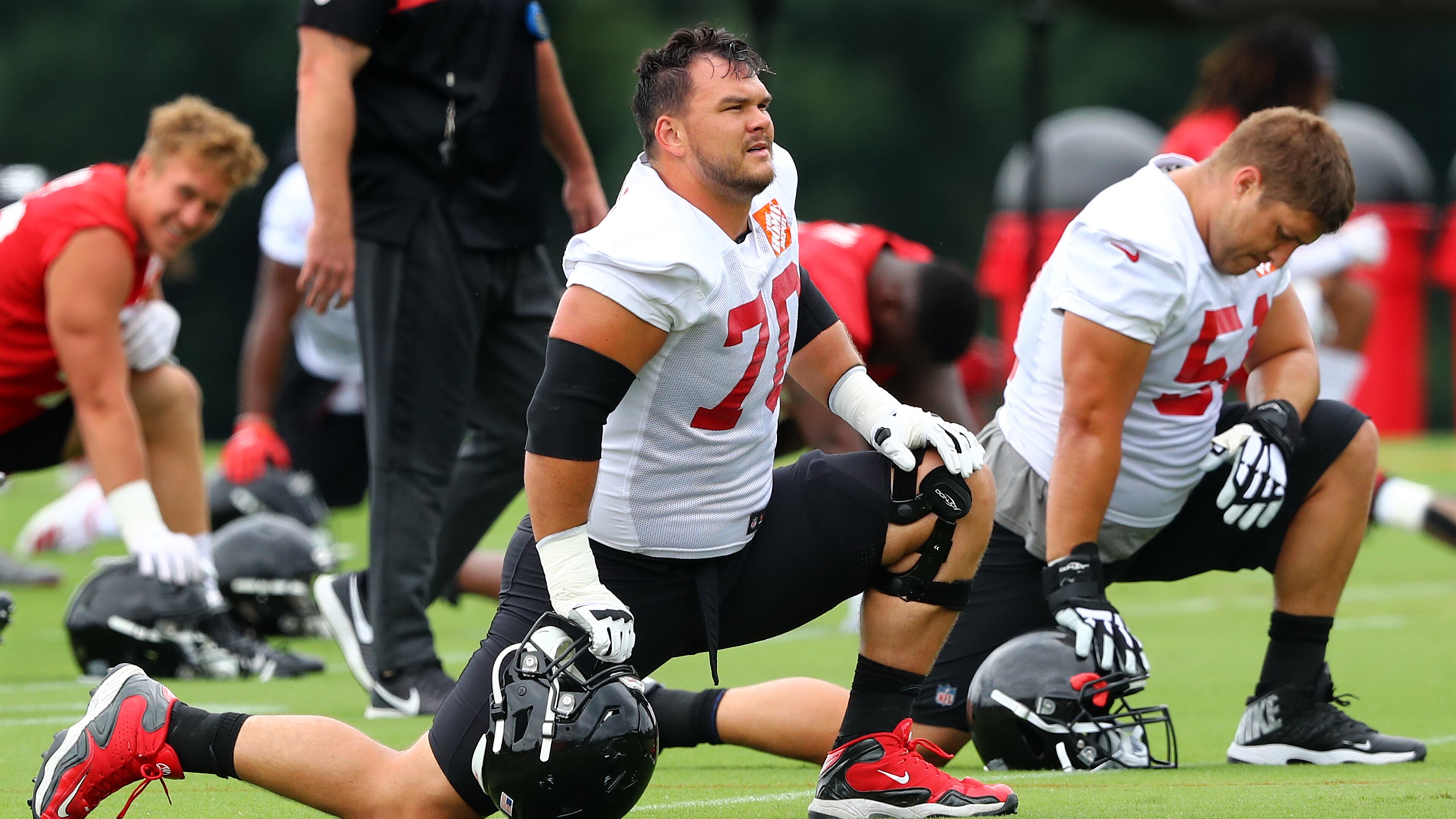 Tackle Jake Matthews (left) and center Alex Mack stretch out during minicamp. (Curtis Compton/ccompton@ajc.com)