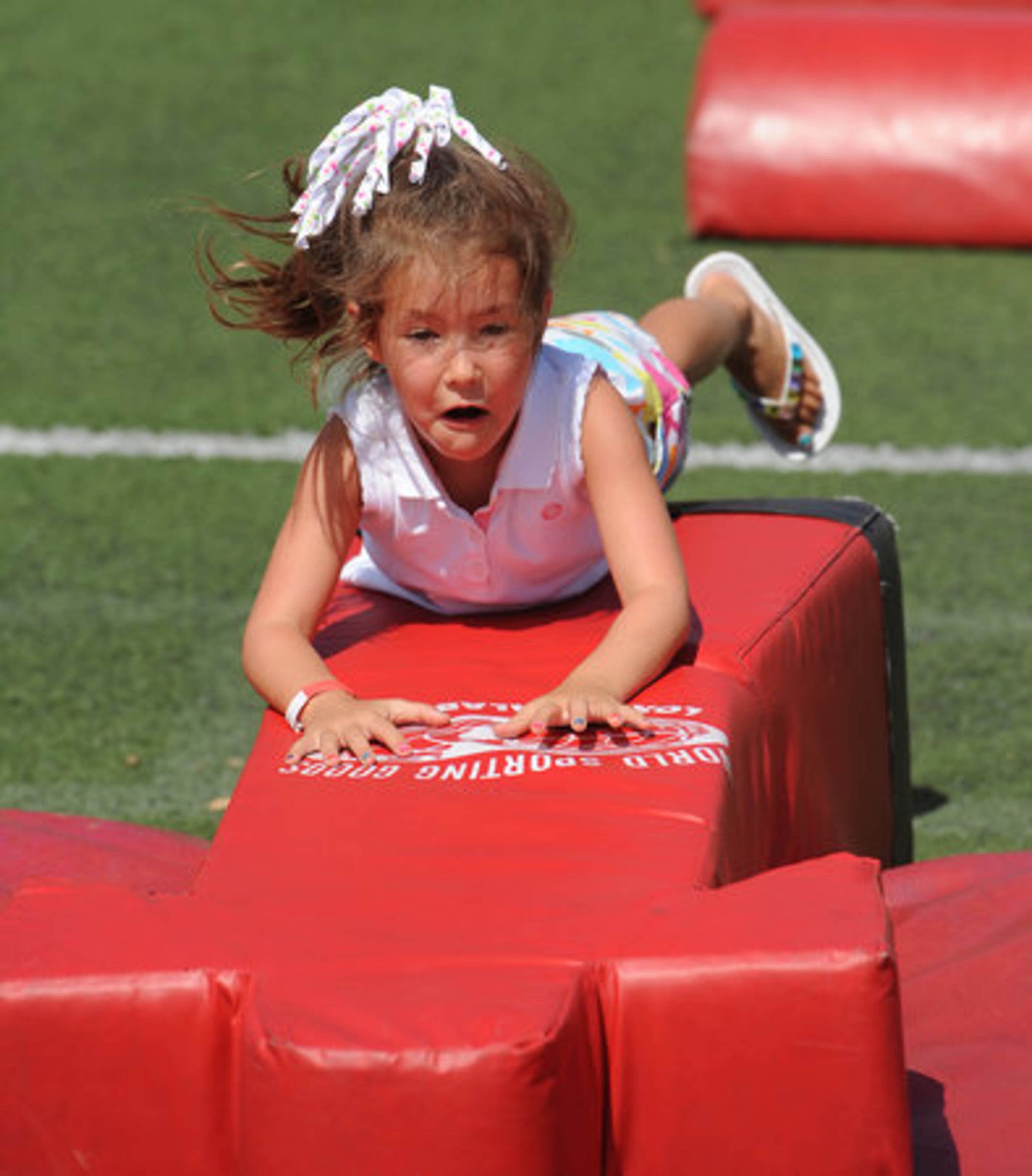 Addison Suchka, 5, jumps on a football dummy.