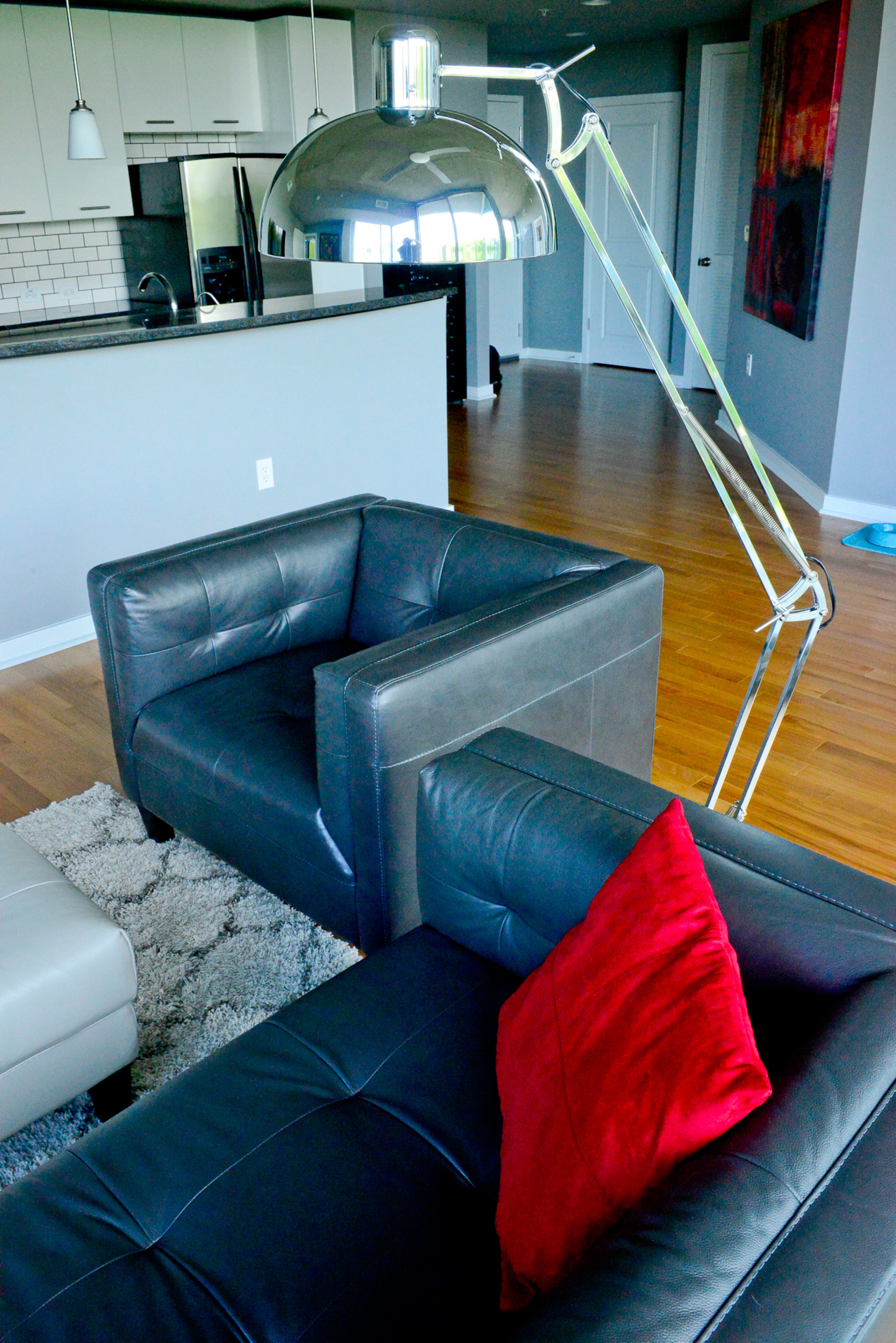 Leather chairs from Z Gallerie and a chrome light fixture match the modern vibe in the Atlanta condo. The ceiling, concrete pillars and walls are painted Grant Gray.