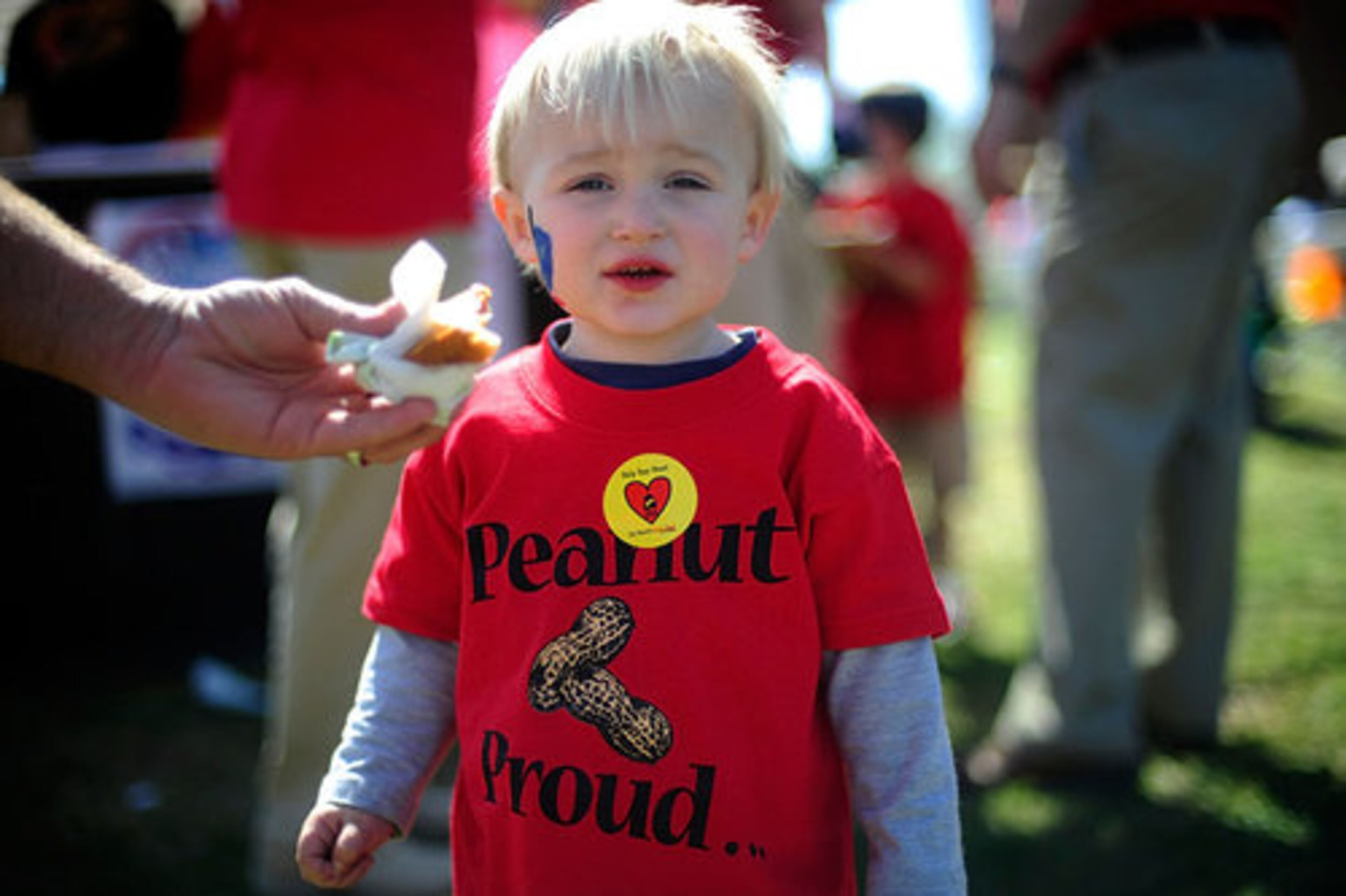 Lake Johnson, 2, from Decatur, Ala, gets an offering of a fried peanut butter sandwich from his father.