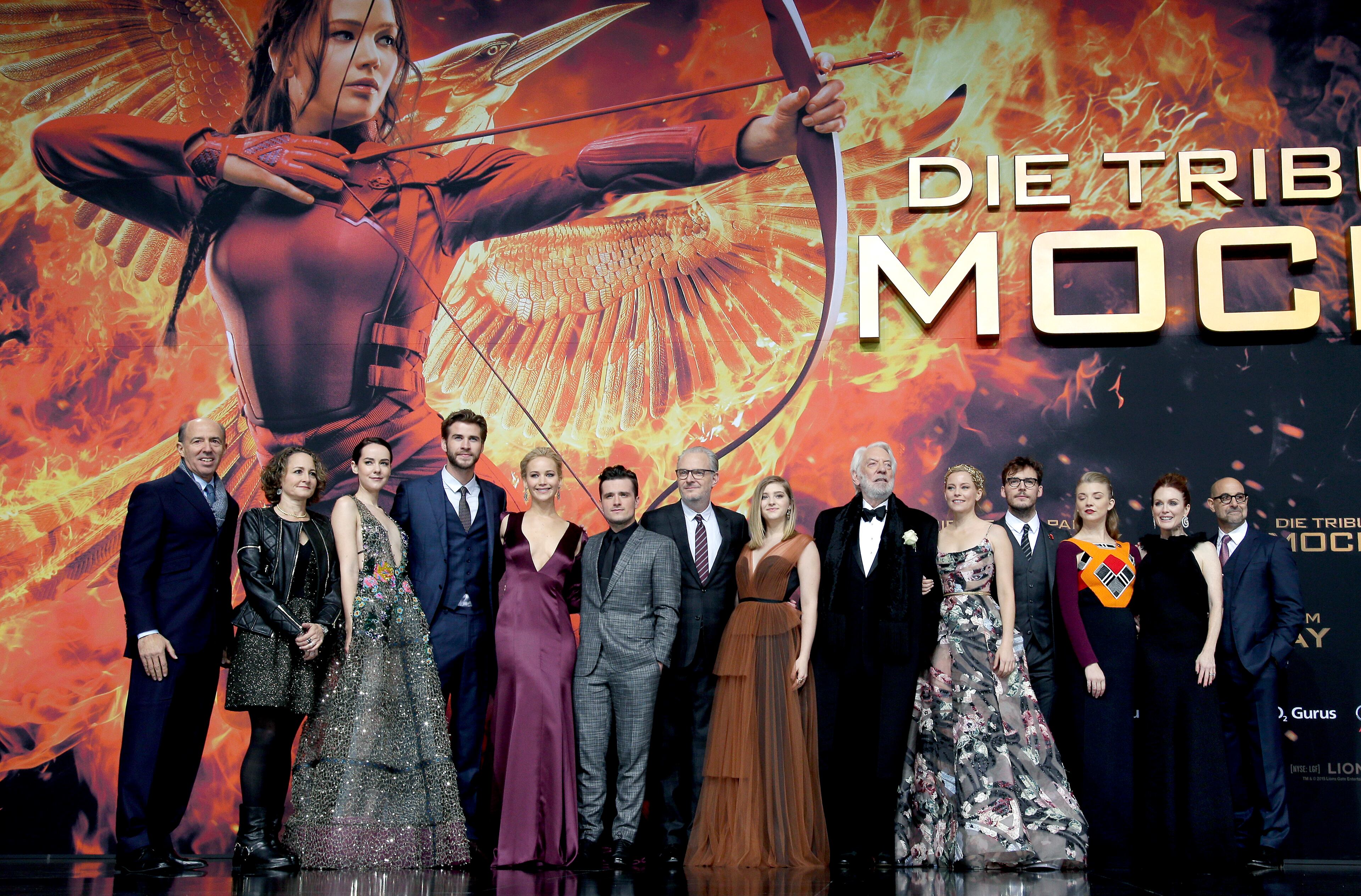 Producers Jon Kilik, and Nina Jacobson, actress Jena Malone, actor Liam Hemsworth, actress Elizabeth Banks, actor Josh Hutcherson, director Francis Lawrence, actress Willow Shields, actor Donald Sutherland, actress Elizabeth Banks, actor Sam Caflin, actress Natalie Dormer, actress Julianne More and actor Stanley Tucci, from left, pose for the photographers as they arrive for the World premiere of the movie 'The Hunger Games: Mockingjay - Part 2' in Berlin, Germany, Wednesday, Nov. 4, 2015. (AP Photo/Michael Sohn)