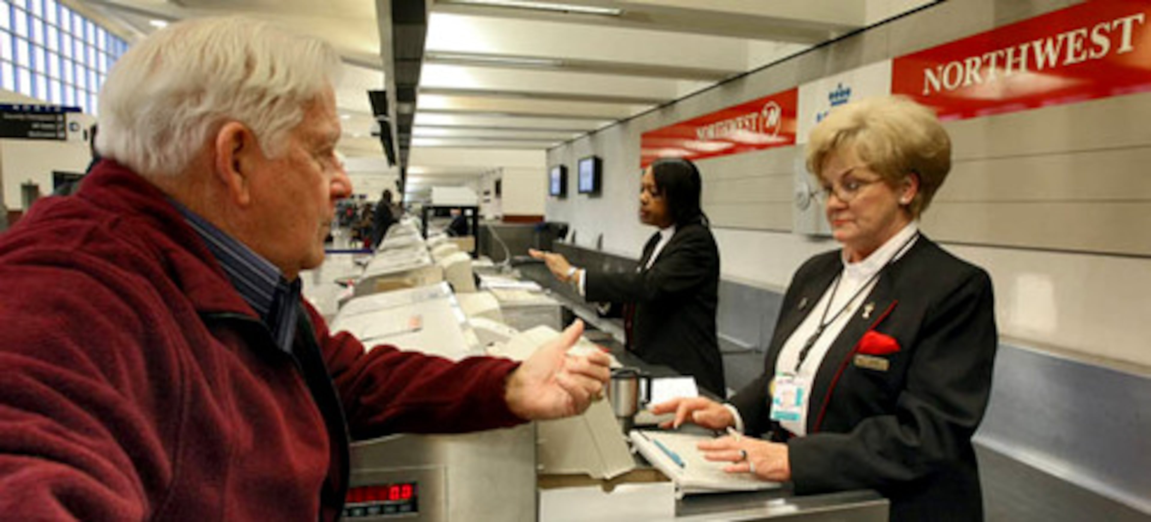 Jim Mellom, 71, from Woodstock speaks with a Northwest ticket agent about his flight to Puerto Rico Tuesday.