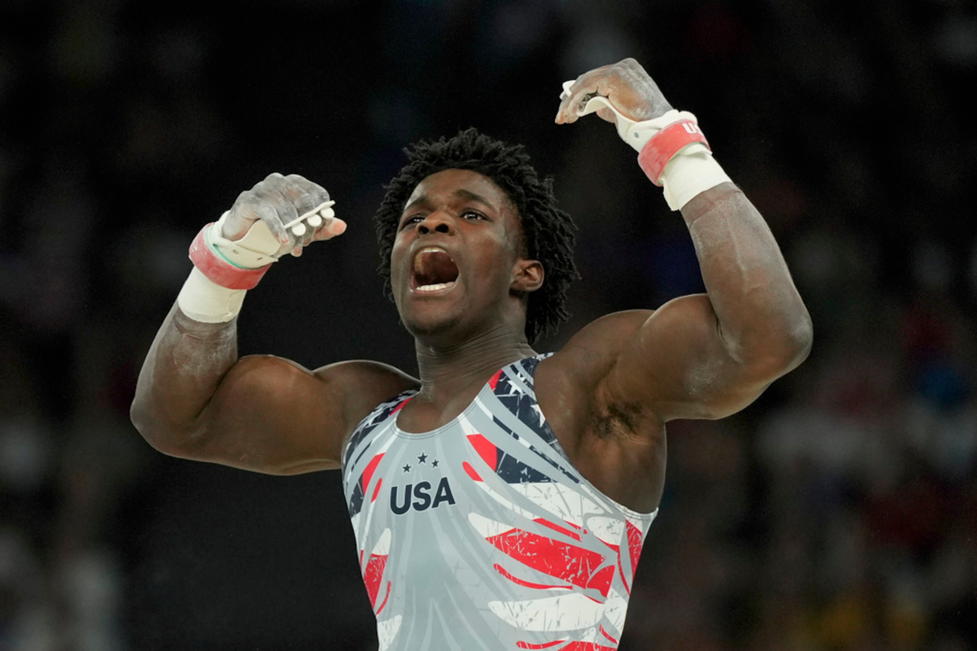 Frederick Richard, of United States, celebrates after performing on the horizontal bar during the men's artistic gymnastics team finals round at Bercy Arena at the 2024 Summer Olympics, Monday, July 29, 2024, in Paris, France. (AP Photo/Charlie Riedel)