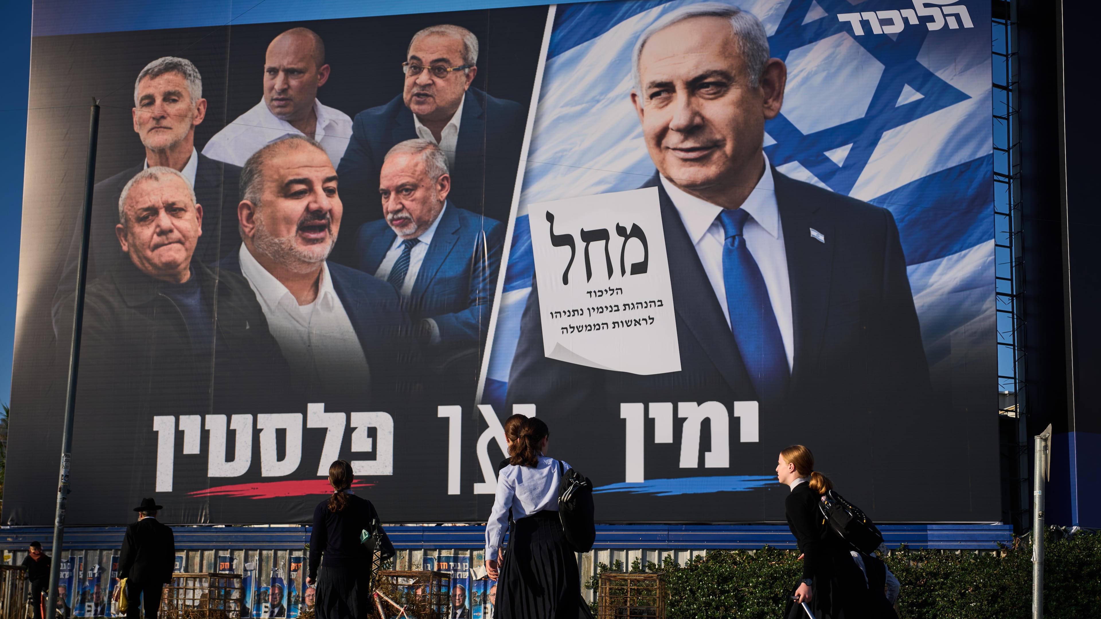 FILE - People walk past a Likud party campaign billboard featuring Israeli Prime Minister Benjamin Netanyahu alongside opposition party leaders and bearing the Hebrew slogan "Right or Palestine," ahead of Israel's general election, in Beni Brak, Israel, Sunday, Oct. 18, 2026. (AP Photo/Oded Balilty, File)