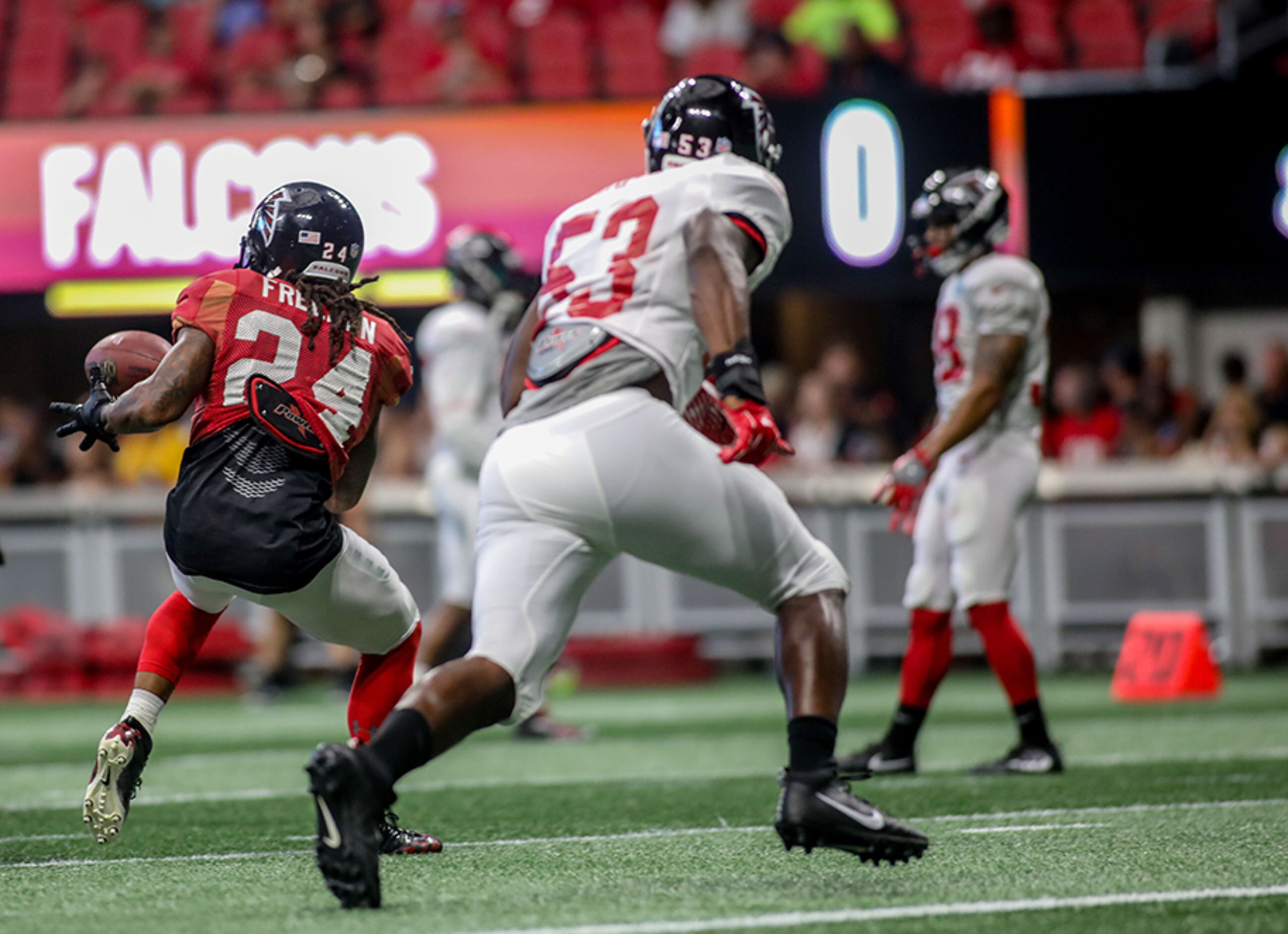 Atlanta Falcons running back Devonta Freeman (24) makes a catch while being defended by linebacker Emmanuel Smith (53) during open practice Sunday, July 29, 2018, at Mercedes-Benz Stadium in Atlanta.