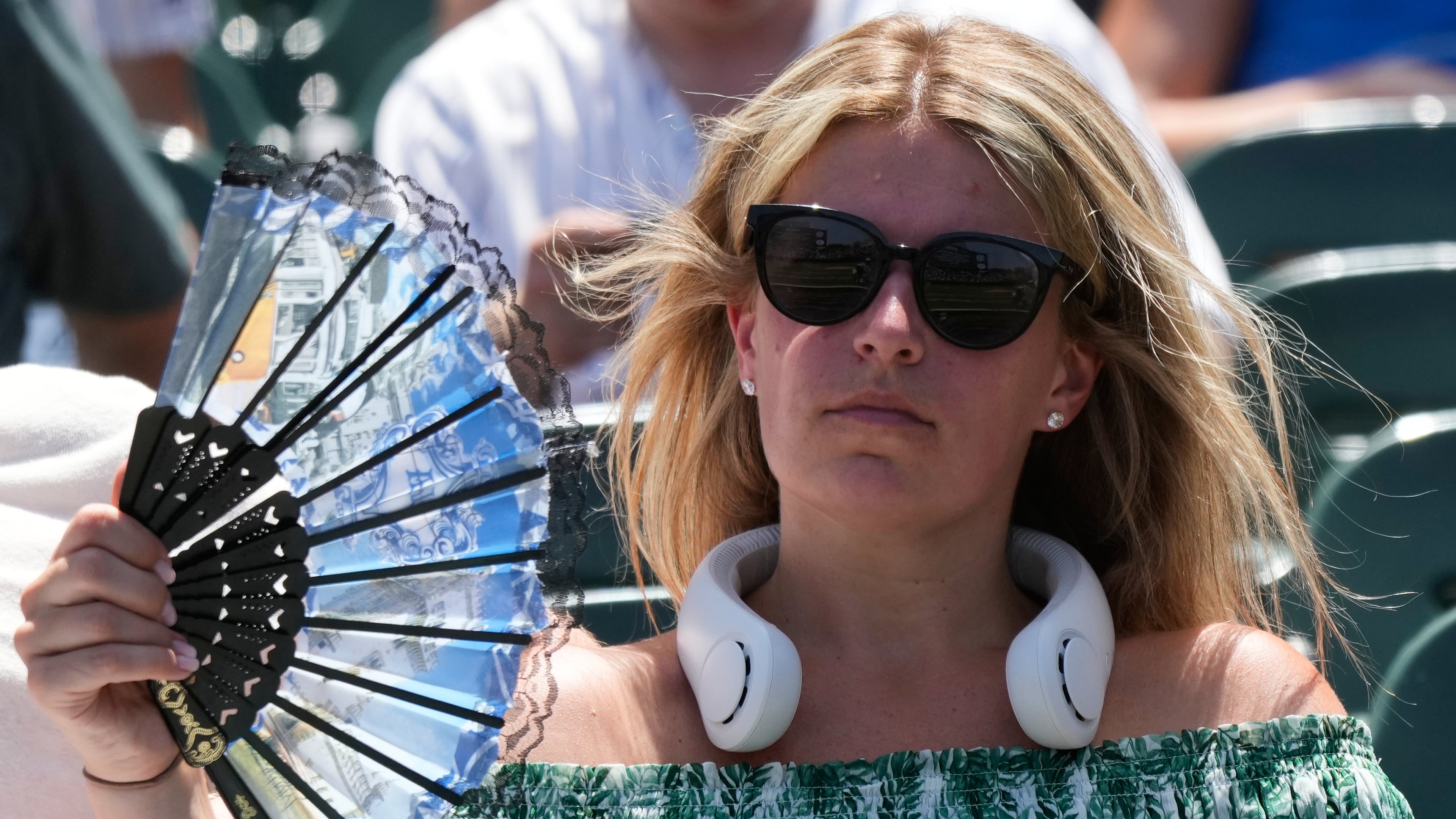 FILE - A baseball fan cools off before a game between the San Diego Padres and the Chicago Cubs in Chicago, July 1, 2026. (AP Photo/Nam Y. Huh, File)