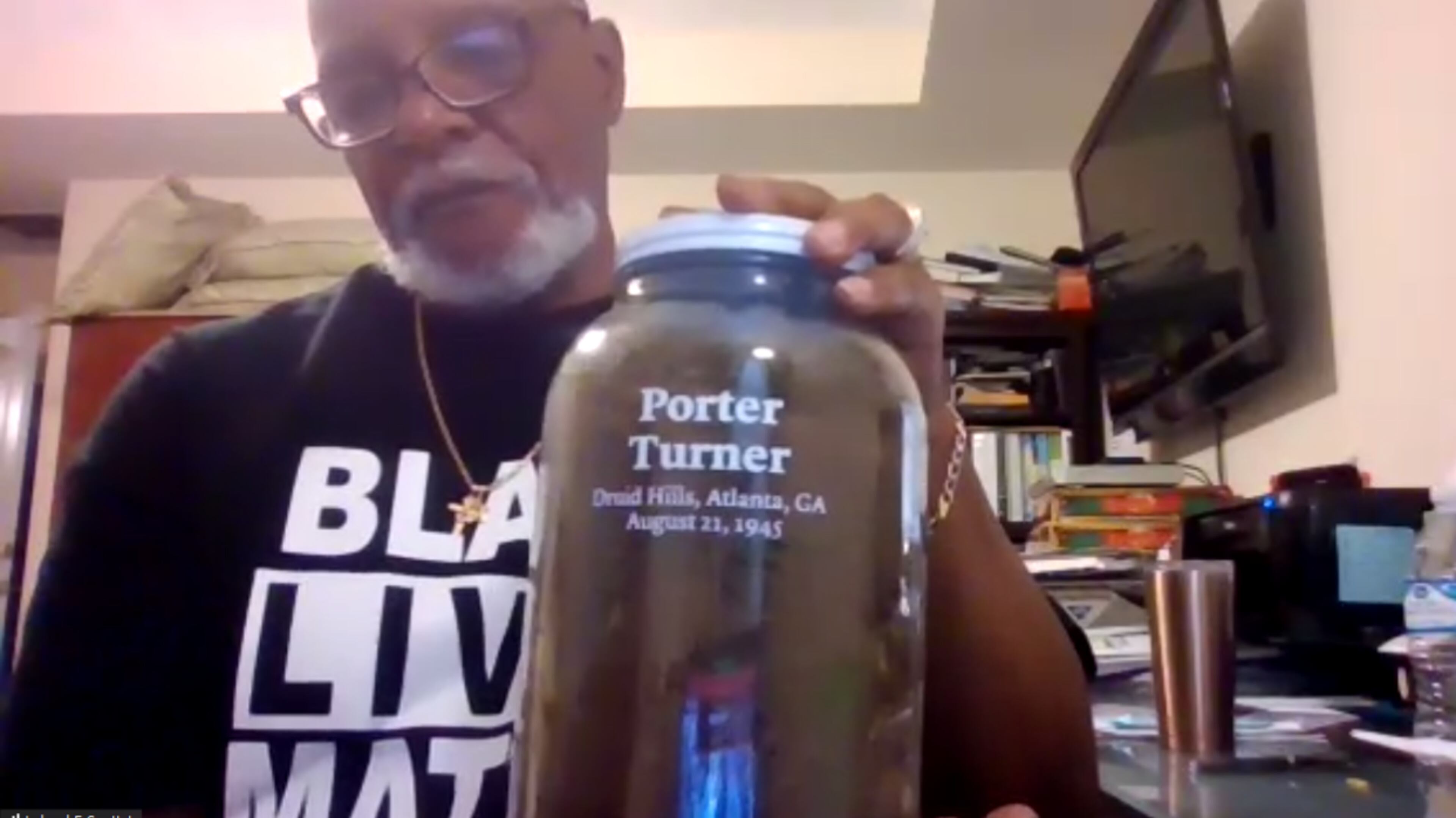 Leland Scott Jr. shows off a jar used to collect soil from the Druid Hills address where Porter Turner was found dead on Aug. 21, 1945. Members of the Ku Klux Klan are suspected of stabbing Turner to death, making him DeKalb County's last known lynching victim. Screenshot taken during the family Zoom call to honor the 75th anniversary or Turner's death.