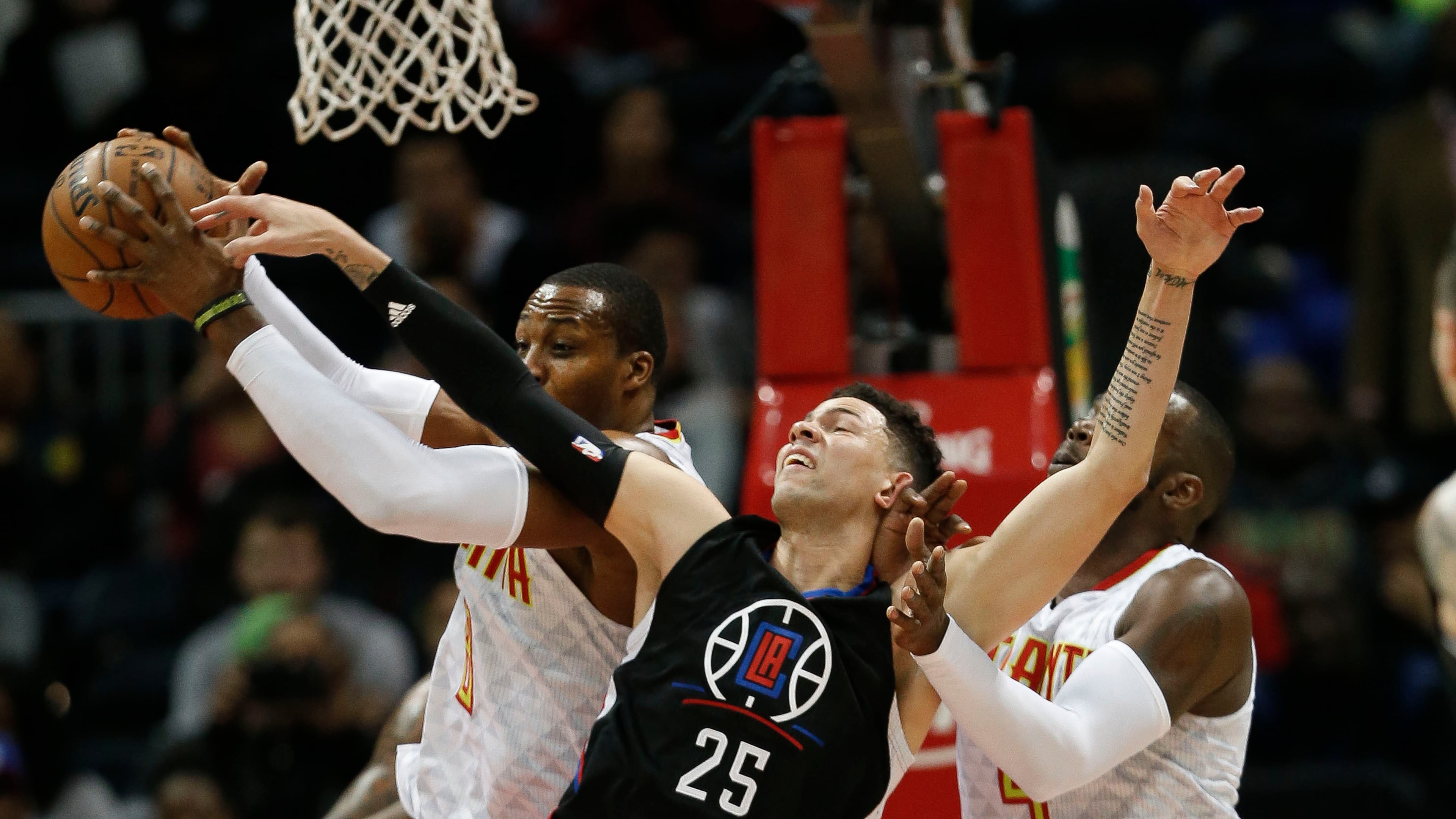 Los Angeles Clippers guard Austin Rivers (25) battles Atlanta Hawks center Dwight Howard (8) and forward Paul Millsap (4) for a rebound in the first half of an NBA basketball game, Monday, Jan. 23, 2017, in Atlanta. (AP Photo/John Bazemore)