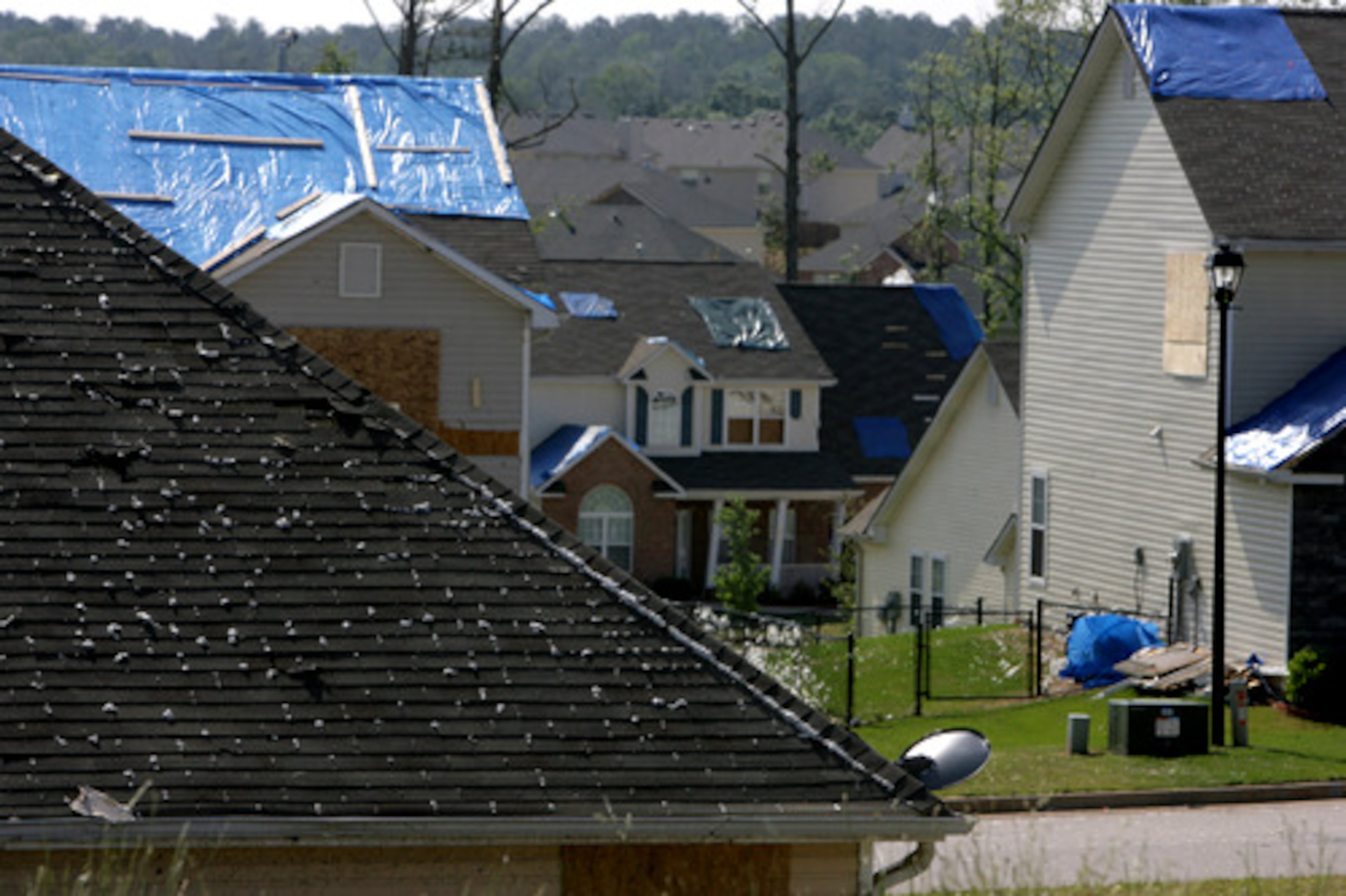 Blue tarps cover houses in Stagecoach Village subdivision in Clayton County. Residents are cleaning up and repairing after the tornado Sunday morning damaged nearly 200 homes in the county.