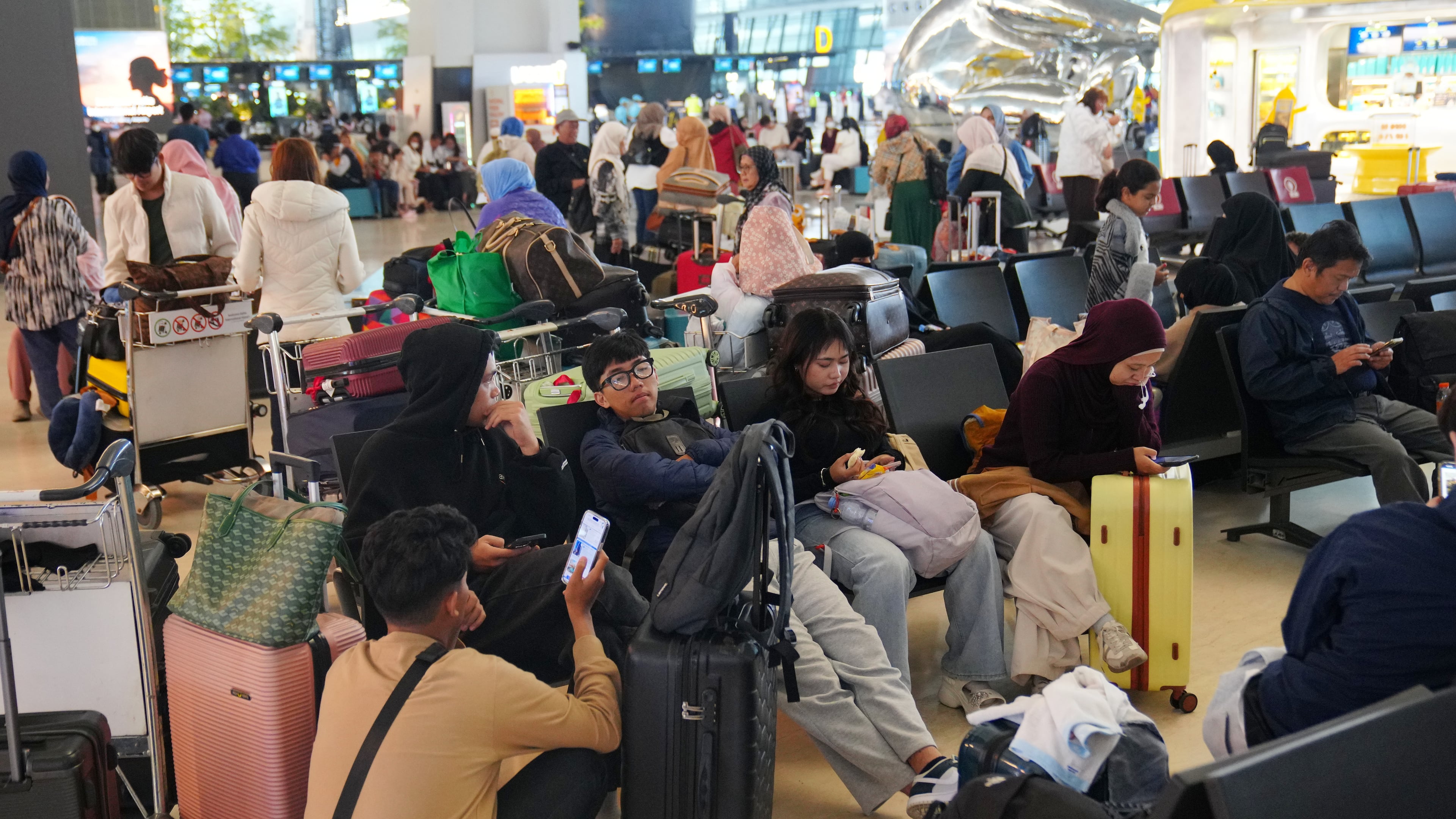 People wait as flights are disrupted due to the eruption of Mount Anak Krakatau, at Soekarno-Hatta International Airport in Tangerang, Indonesia, Monday, Sept. 7, 2026. (AP Photo/Tatan Syuflana)