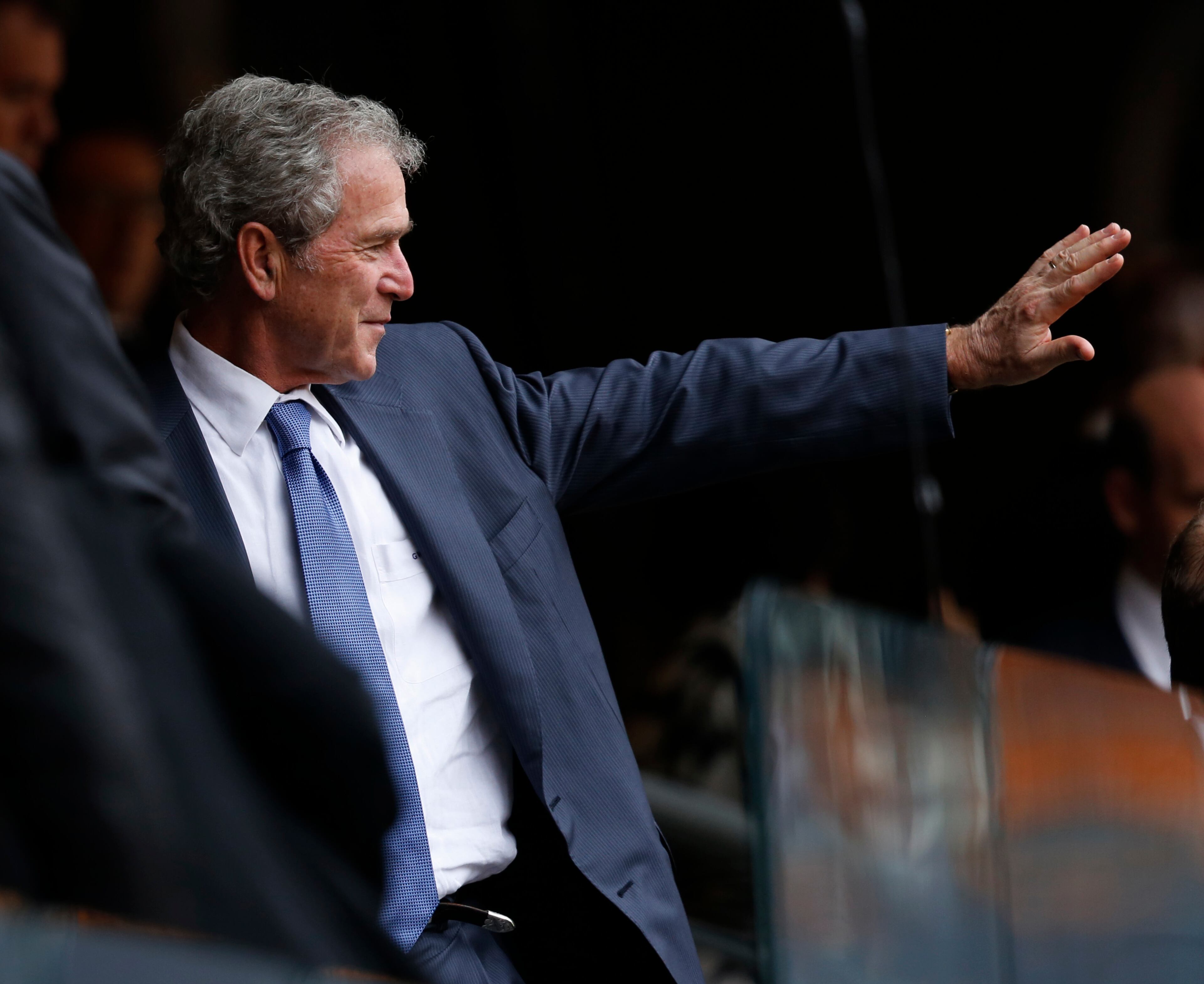 Former U.S. President George W. Bush waves during the memorial service for former South African president Nelson Mandela at the FNB Stadium in Soweto near Johannesburg, Tuesday, Dec. 10, 2013. (AP Photo/Ben Curtis)