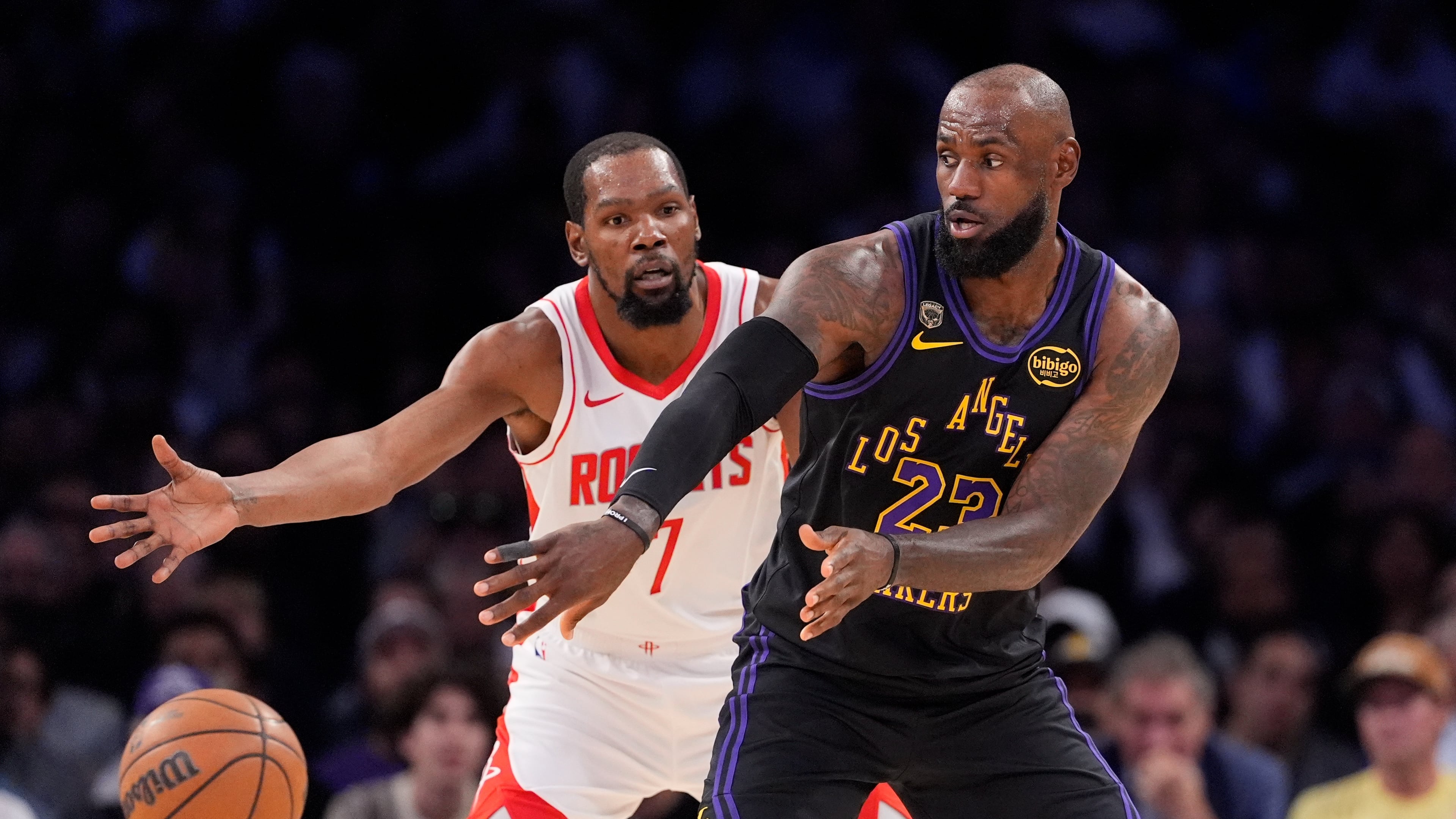 Los Angeles Lakers forward LeBron James, right, passes the ball while under pressure from Houston Rockets forward Kevin Durant during the first half in Game 2 of a first-round NBA playoffs basketball series Tuesday, April 21, 2026, in Los Angeles. (AP Photo/Mark J. Terrill)