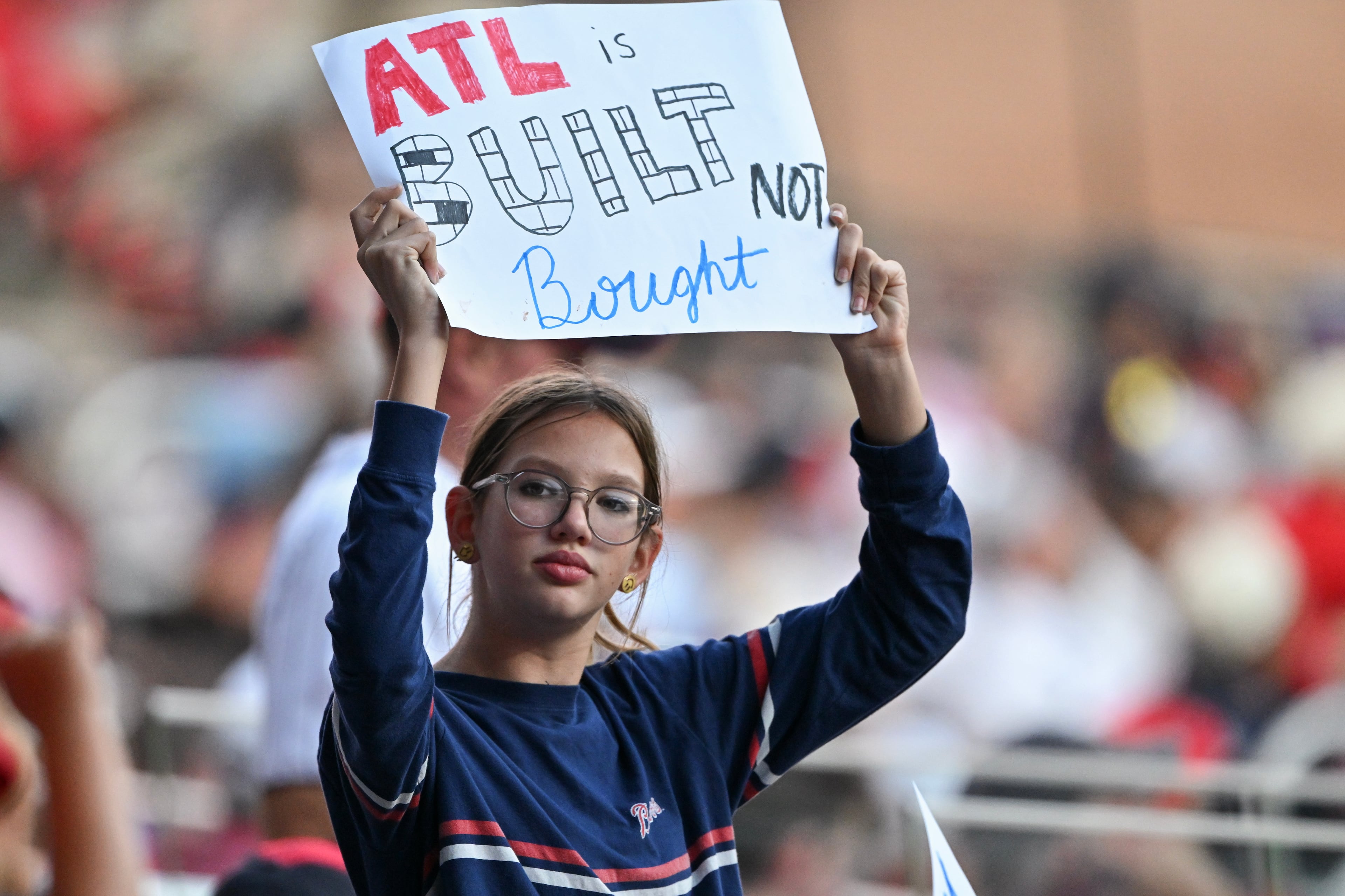 A young fan holds a supportive sign during Game 4 of the MLB National League Division Series between the Atlanta Braves and the Los Angeles Dodgers, Wednesday, Oct. 7, 2026, in Atlanta. (Hyosub Shin/AJC)