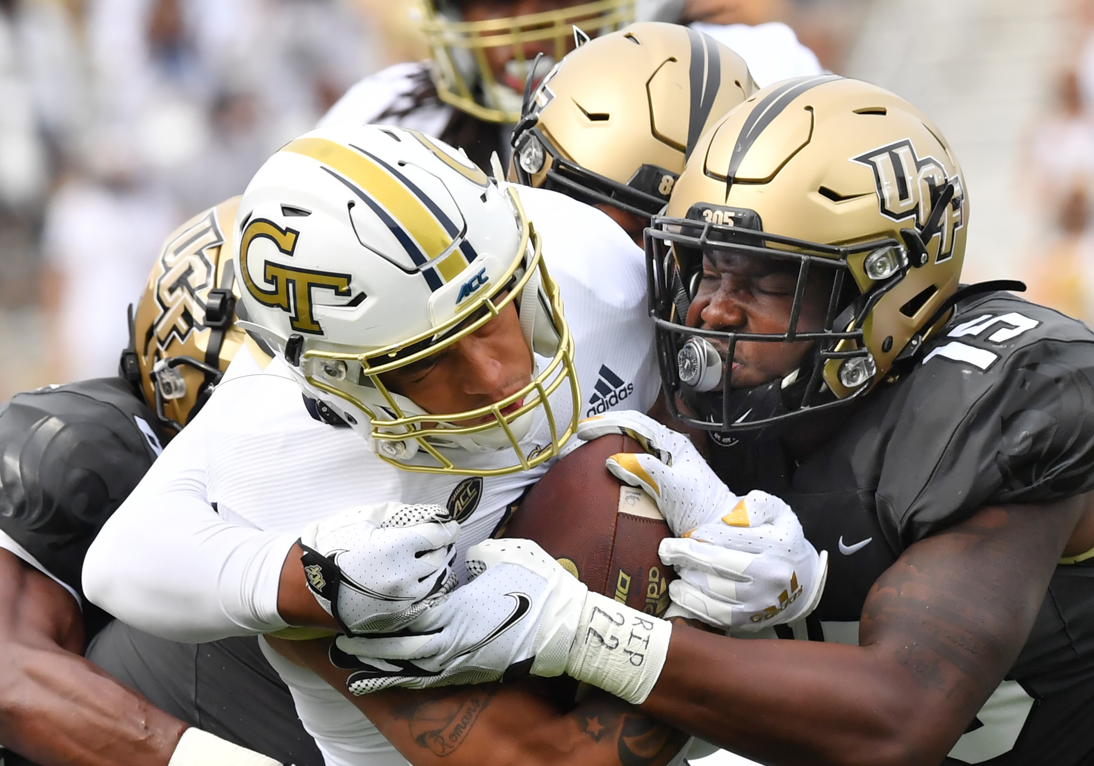 Georgia Tech's running back Dontae Smith (28) is brought down by University of Central Florida's defensive lineman Tre'mon Morris-Brash (behind) and linebacker Tatum Bethune (15). (Hyosub Shin / Hyosub.Shin@ajc.com)