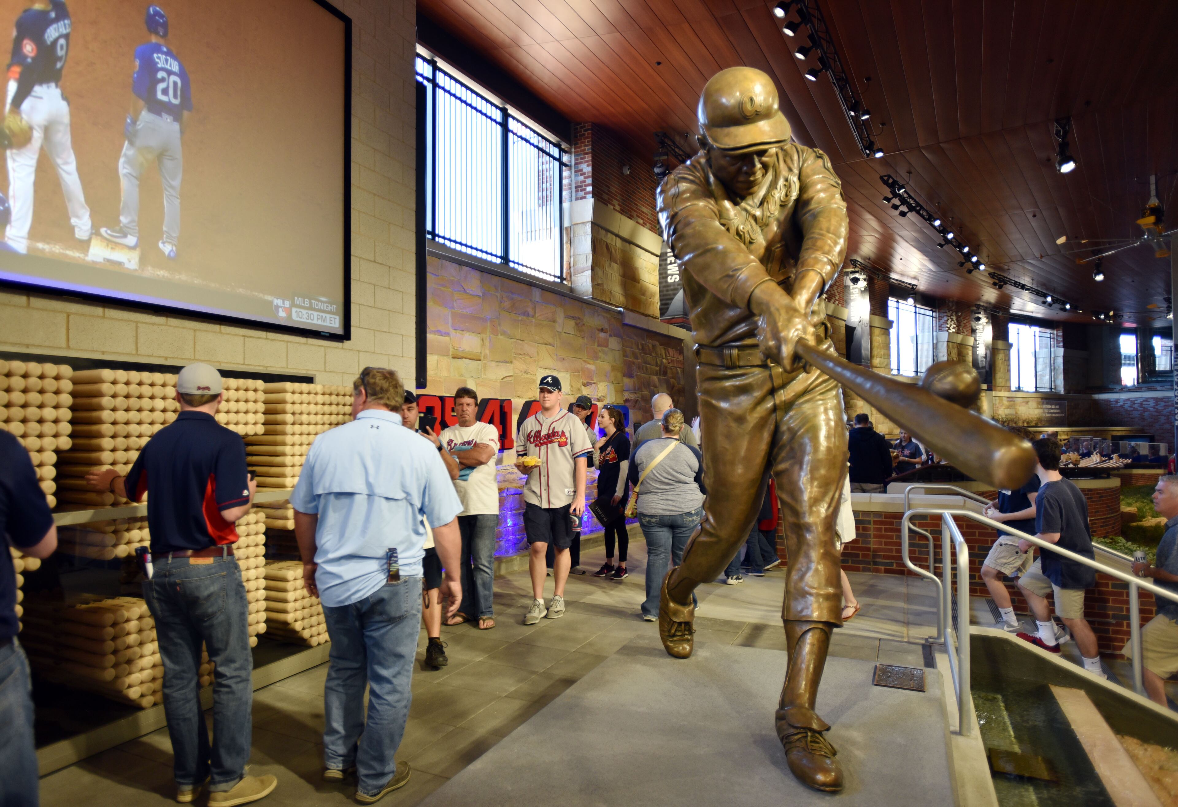 MARCH 31, 2017 ATLANTA Fans walk past the Hank Aaron statue in the Braves Monument Garden in the stadium as they wait for the Atlanta Braves to take the field in an exhibition game against the New York Yankees in the first game in the new SunTrust Park stadium Friday, March 31, 2017. The new home of the Braves seats 41,149 and took 30 months to build. HYOSUB SHIN /hshin@ajc.com