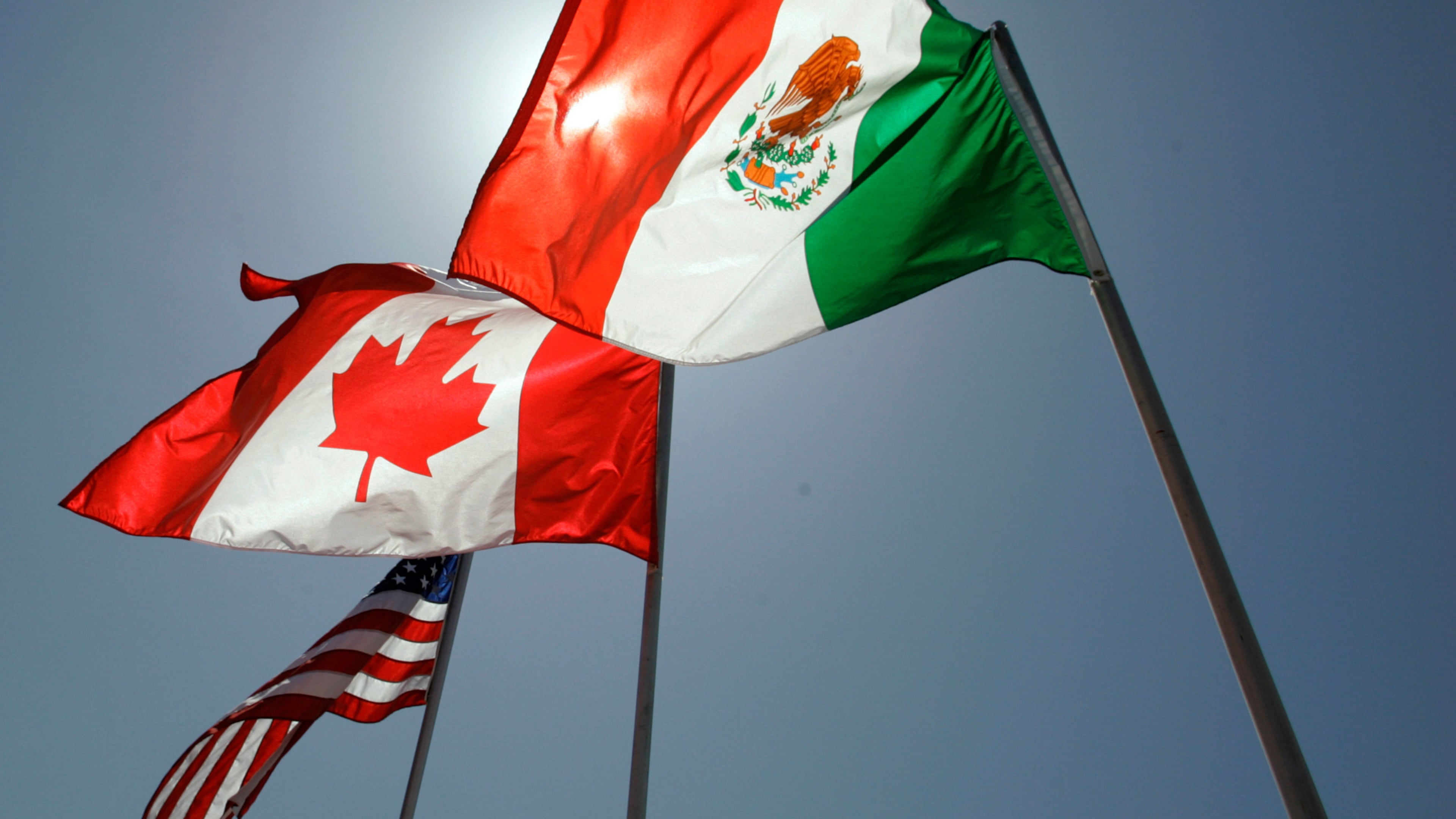 FILE - National flags representing the United States, Canada, and Mexico fly in the breeze in New Orleans where leaders of the North American Free Trade Agreement met on April 21, 2008. (AP Photo/Judi Bottoni, File)