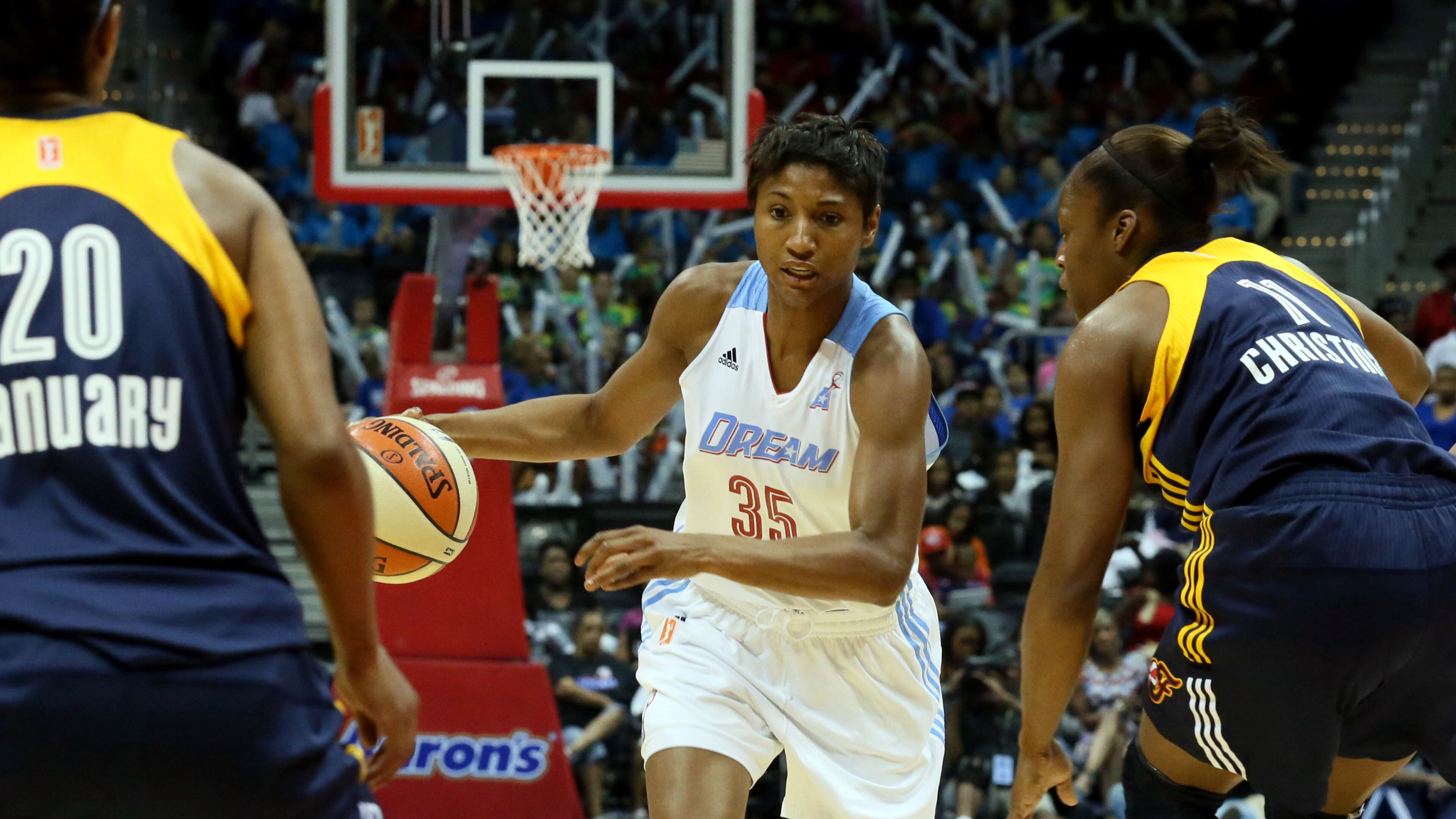 Atlanta Dream's Angel McCoughtry (center) tries to get past two Indiana Fever's players during their game at Philips Arena on Tuesday June 25, 2013.